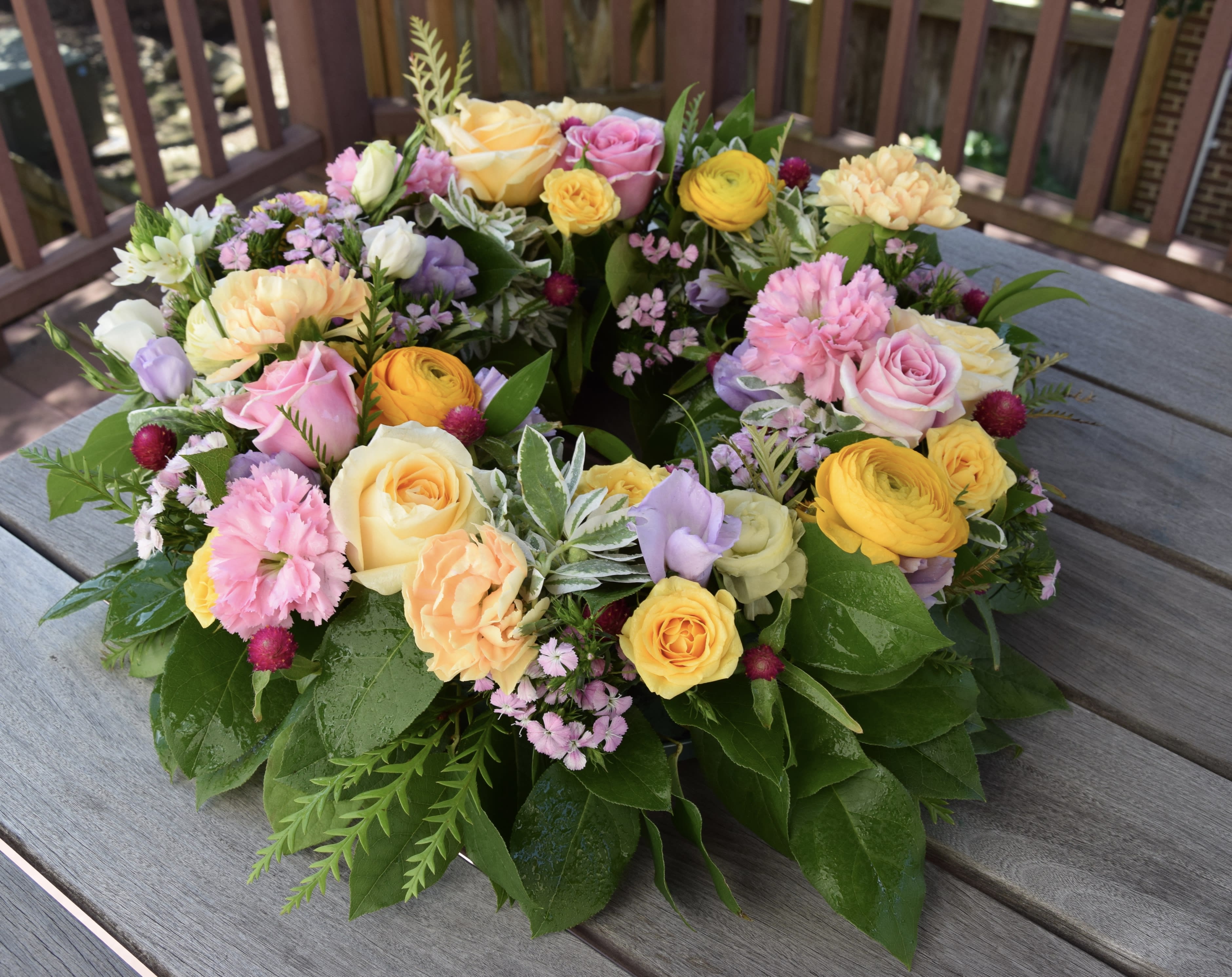 Colorful floral wreath with roses, carnations, and small filler flowers