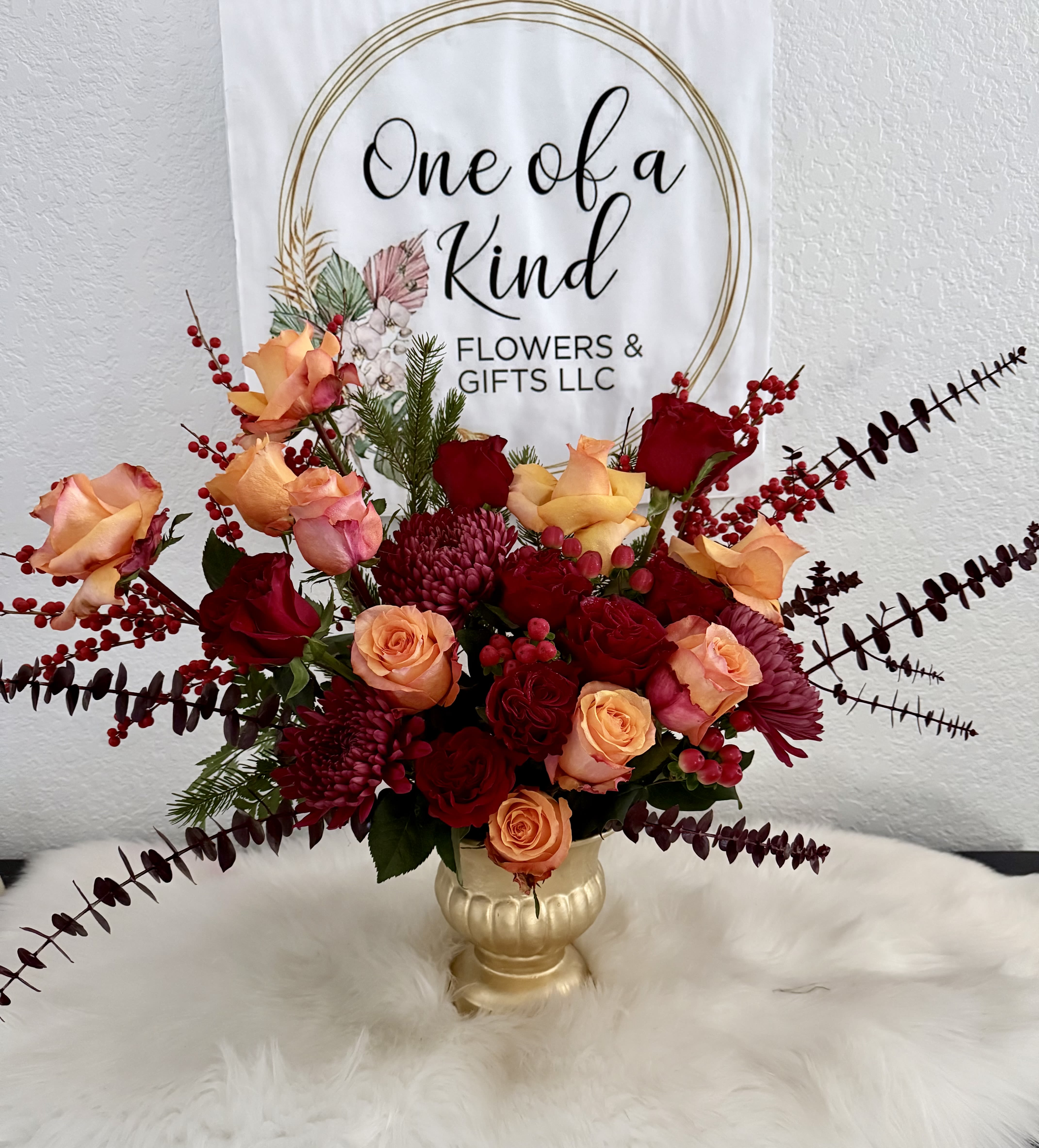 Bouquet of peach and red roses in a gold vase