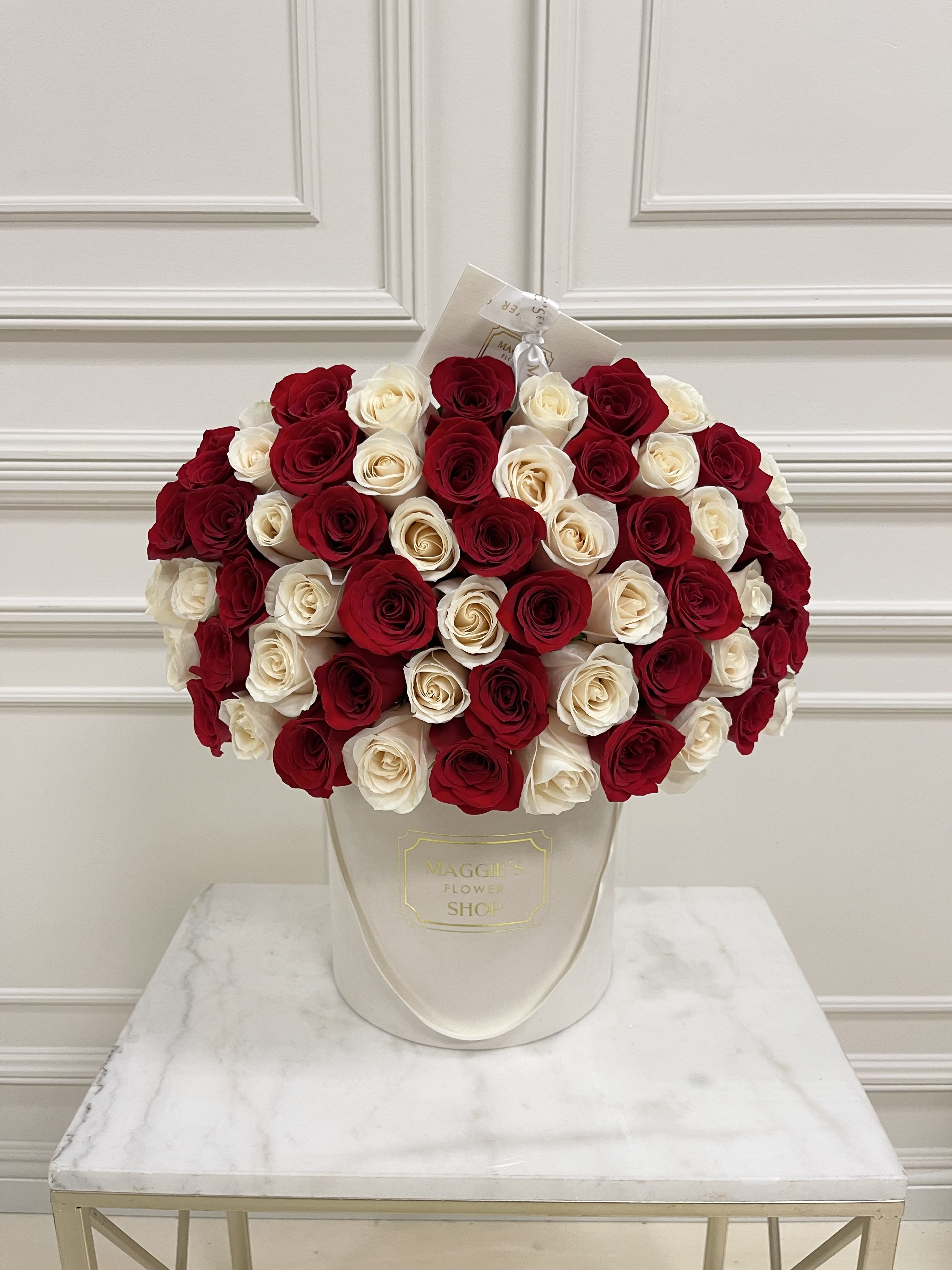 Bouquet of red and white roses in a white hatbox