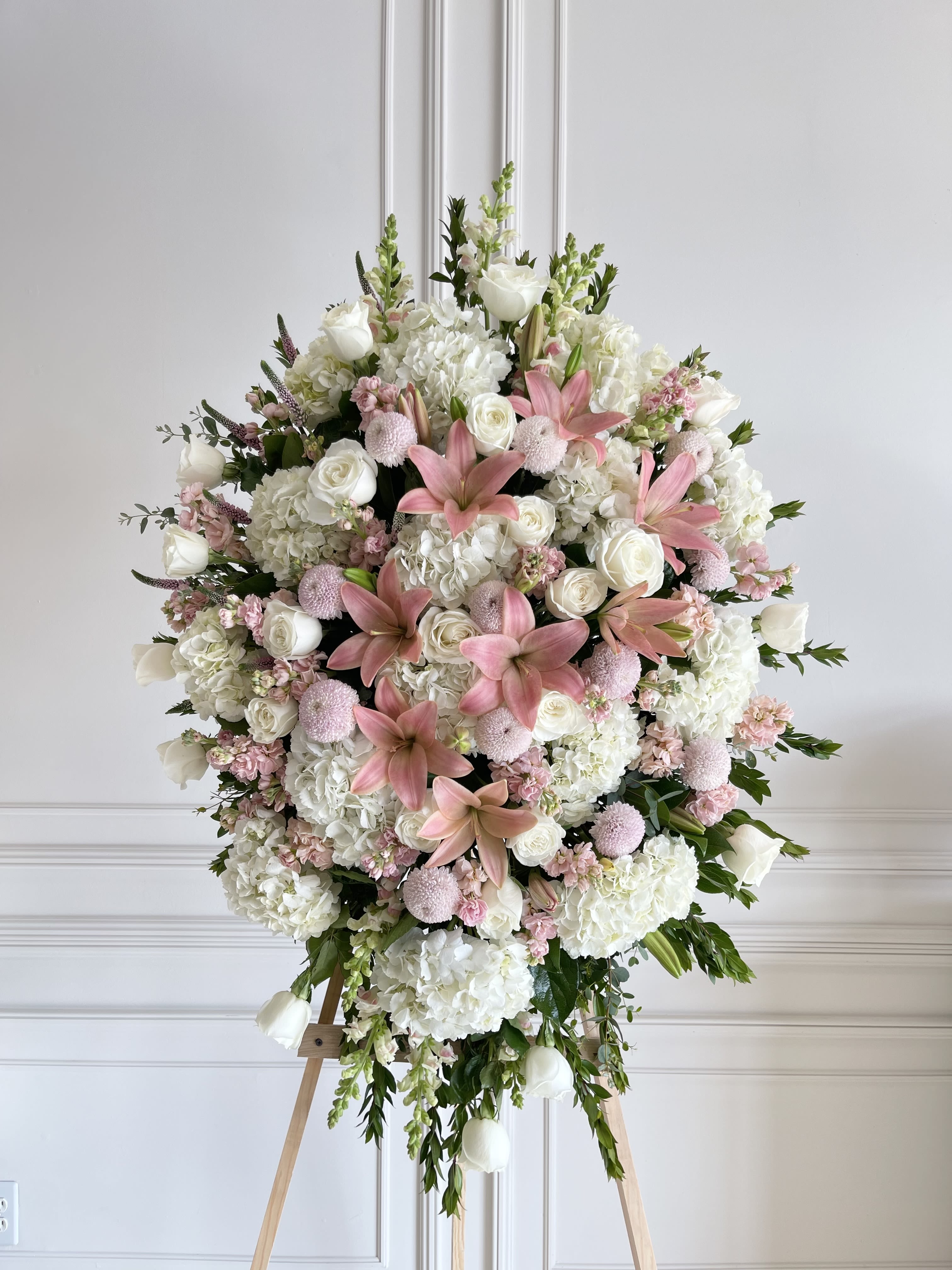 Large pink and white floral standing spray on an easel