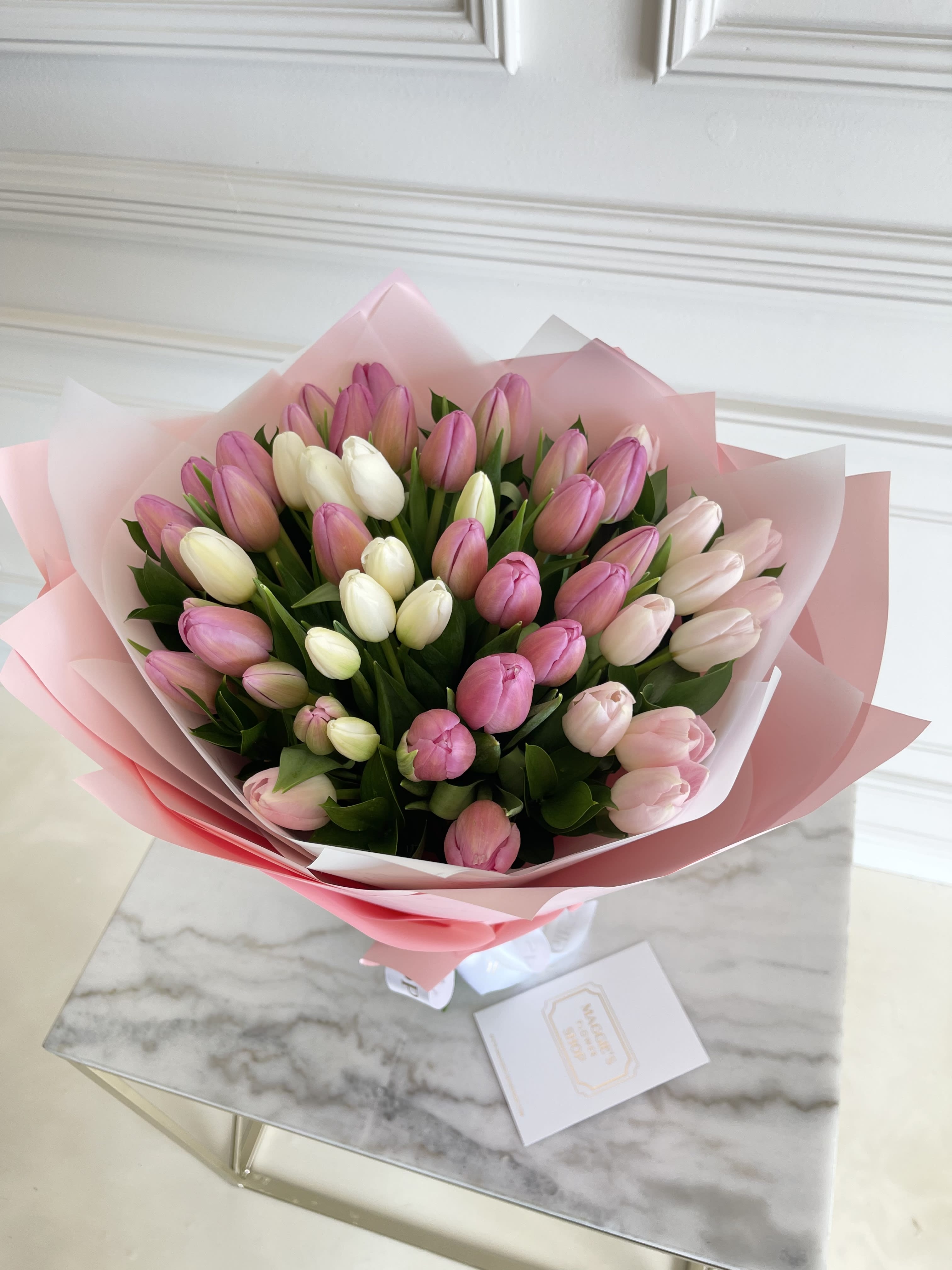 Bouquet of pink and white tulips wrapped in pink paper