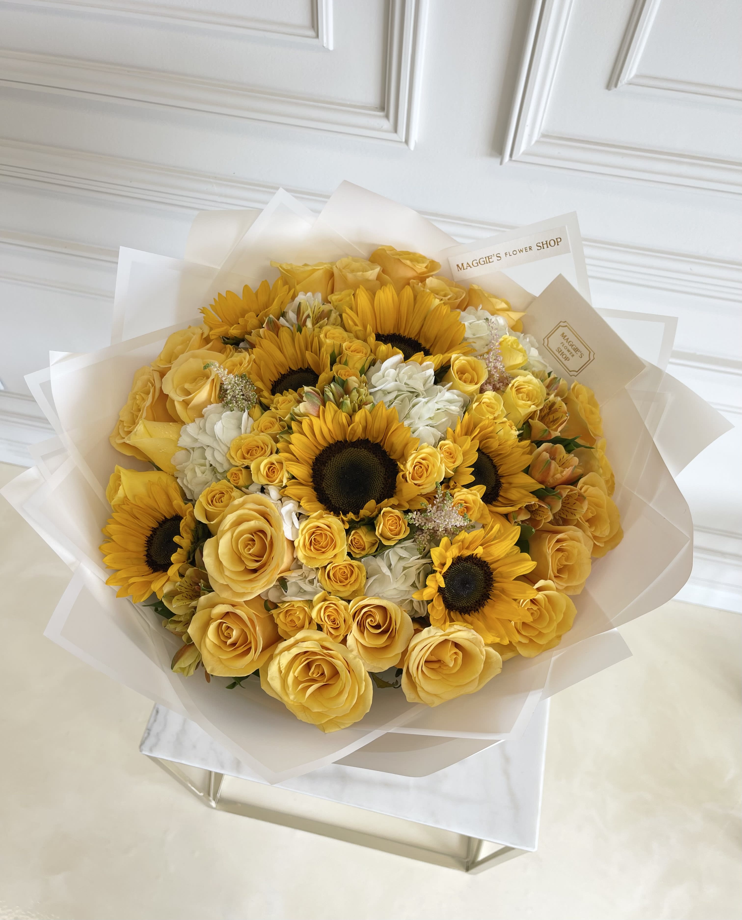 Yellow roses and sunflowers in a wrapped bouquet