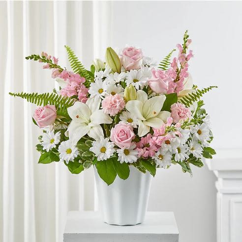 Soft Touch Tabletop Basket -  Pet Friendly? No – This arrangement contains Asiatic Lilies, which are highly toxic to cats, and Daisies, which can cause distress to dogs and cats. Keep out of reach; avoid homes with curious cats as even lily pollen can be dangerous.   Human Allergy Note : This arrangement contains Lilies and Daisies, which are known to be pollen-heavy. To reduce irritation, you may carefully snip the orange anthers from the center of the lilies as they open.   Care &amp; Longevity : This arrangement is designed in floral foam. To ensure longevity, check the foam daily and add a cup of fresh water to the center of the basket to keep it moist. Remove any fading blooms or foliage to keep the water clean and the arrangement looking fresh. Avoid placing the basket in direct sunlight or near HVAC vents.   Best Occasions &amp; Situations : - Memorial or Funeral Service - Get Well / Hospital Delivery - Sympathy for the Home - Birthday Surprise - New Baby Girl - Thinking of You - Just Because   Why Customers Love It : - Soft Color Balance: The mix of cream and pink creates a very calming aesthetic. - Gift-Ready: The woven basket is charming and doesn’t require the recipient to find a vase.  - Versatility: Perfect for both a happy birthday and a respectful sympathy gesture. - Fresh Fragrance: The lilies provide a light, sweet scent that fills a small room.