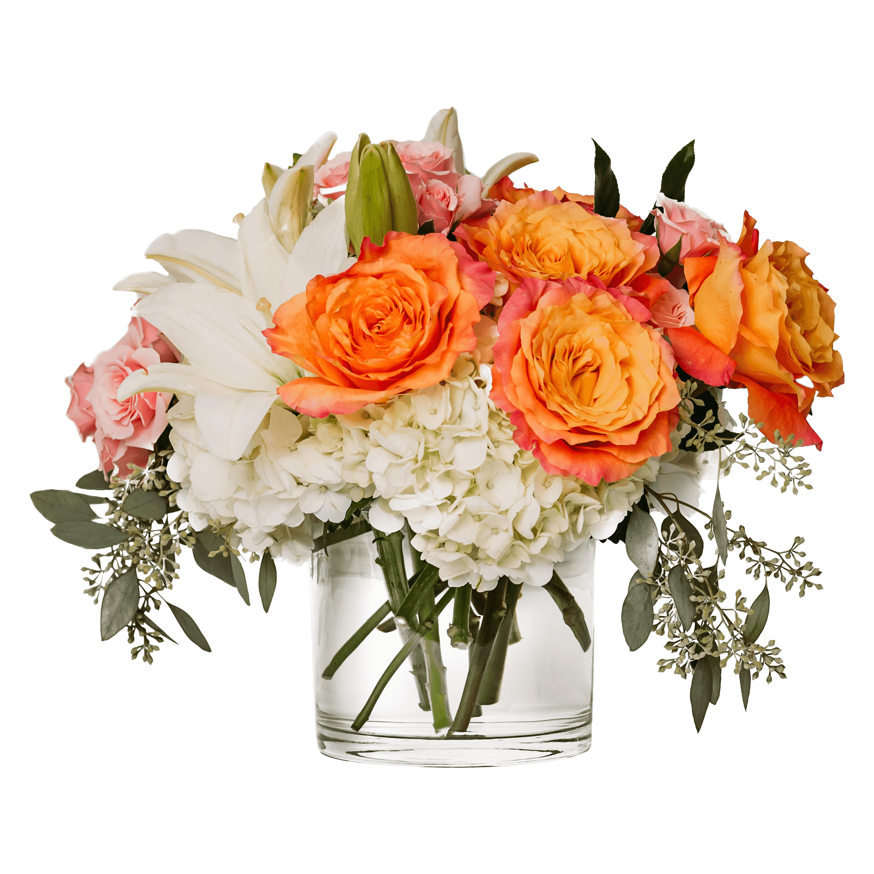 Low glass vase with orange roses, white lilies, white hydrangeas, and pink spray roses in a compact arrangement