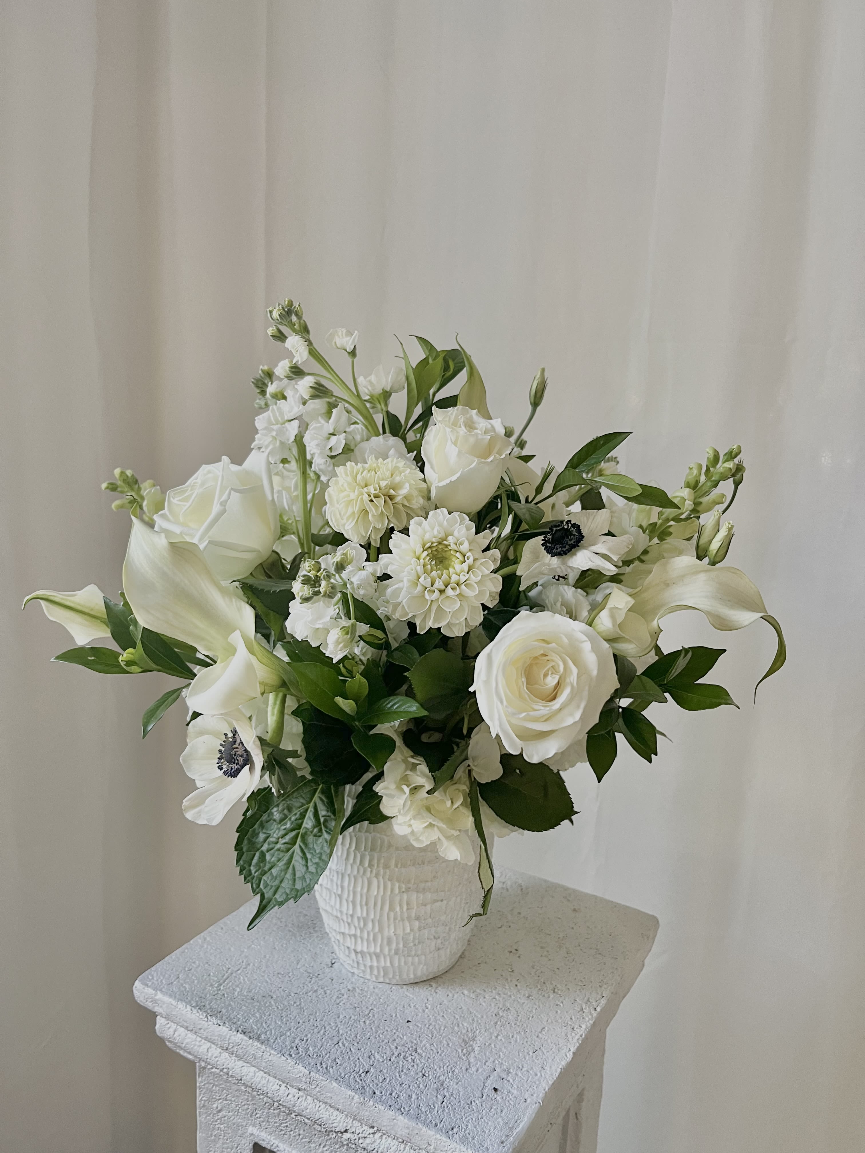 White floral arrangement in a textured white vase