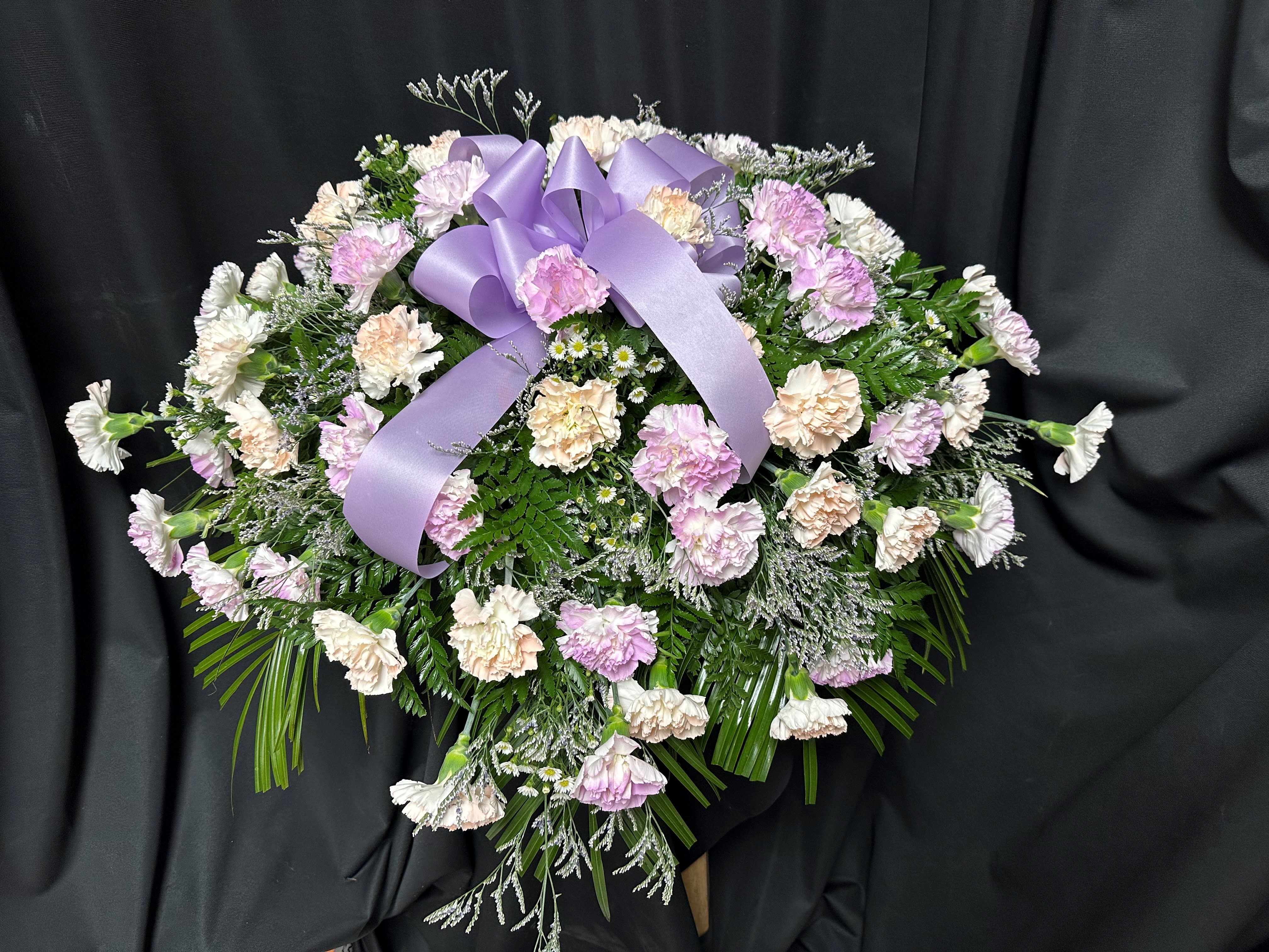 Lavender and white carnation spray with a purple ribbon