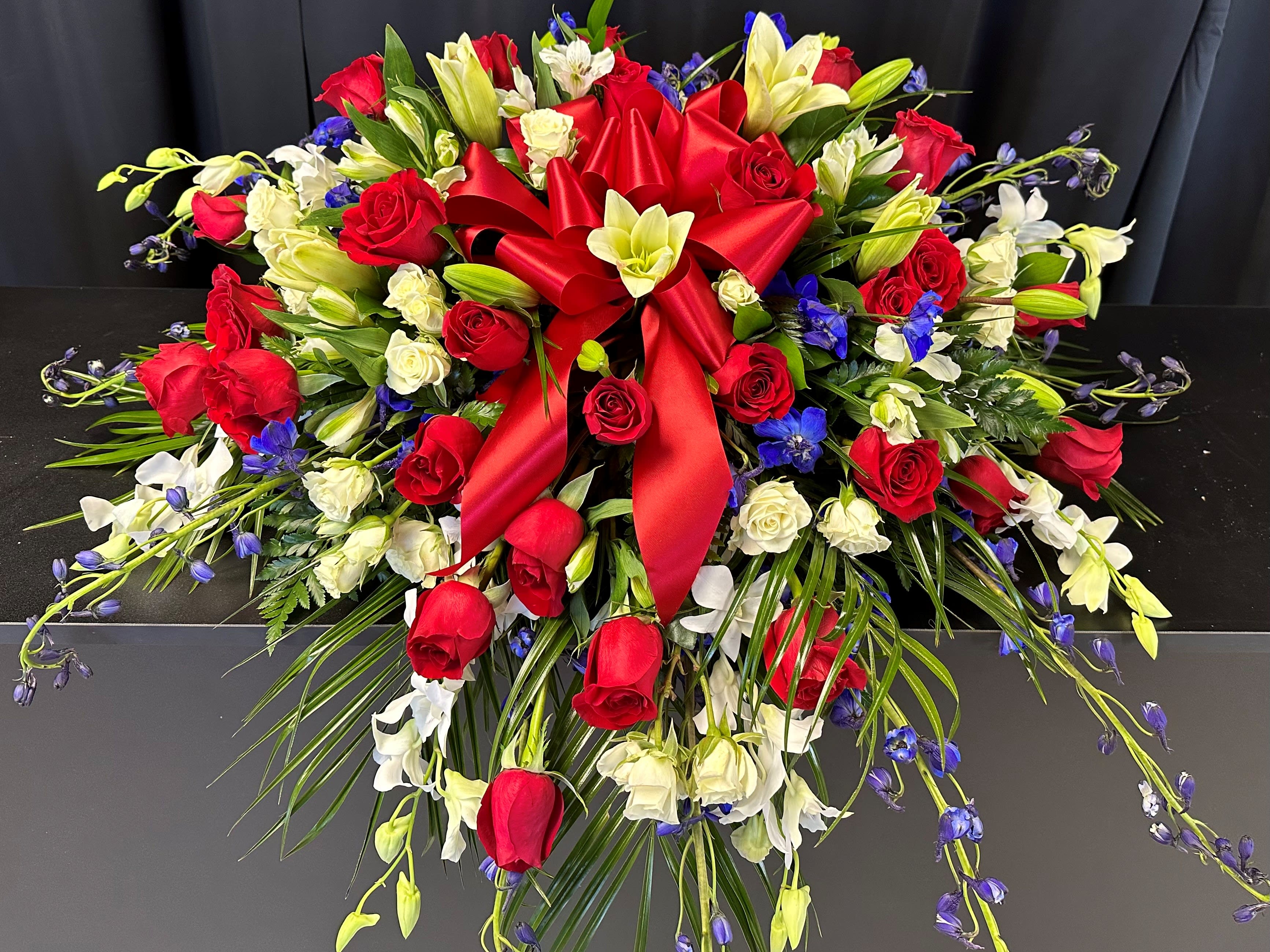 Large red and white floral spray with a red ribbon bow