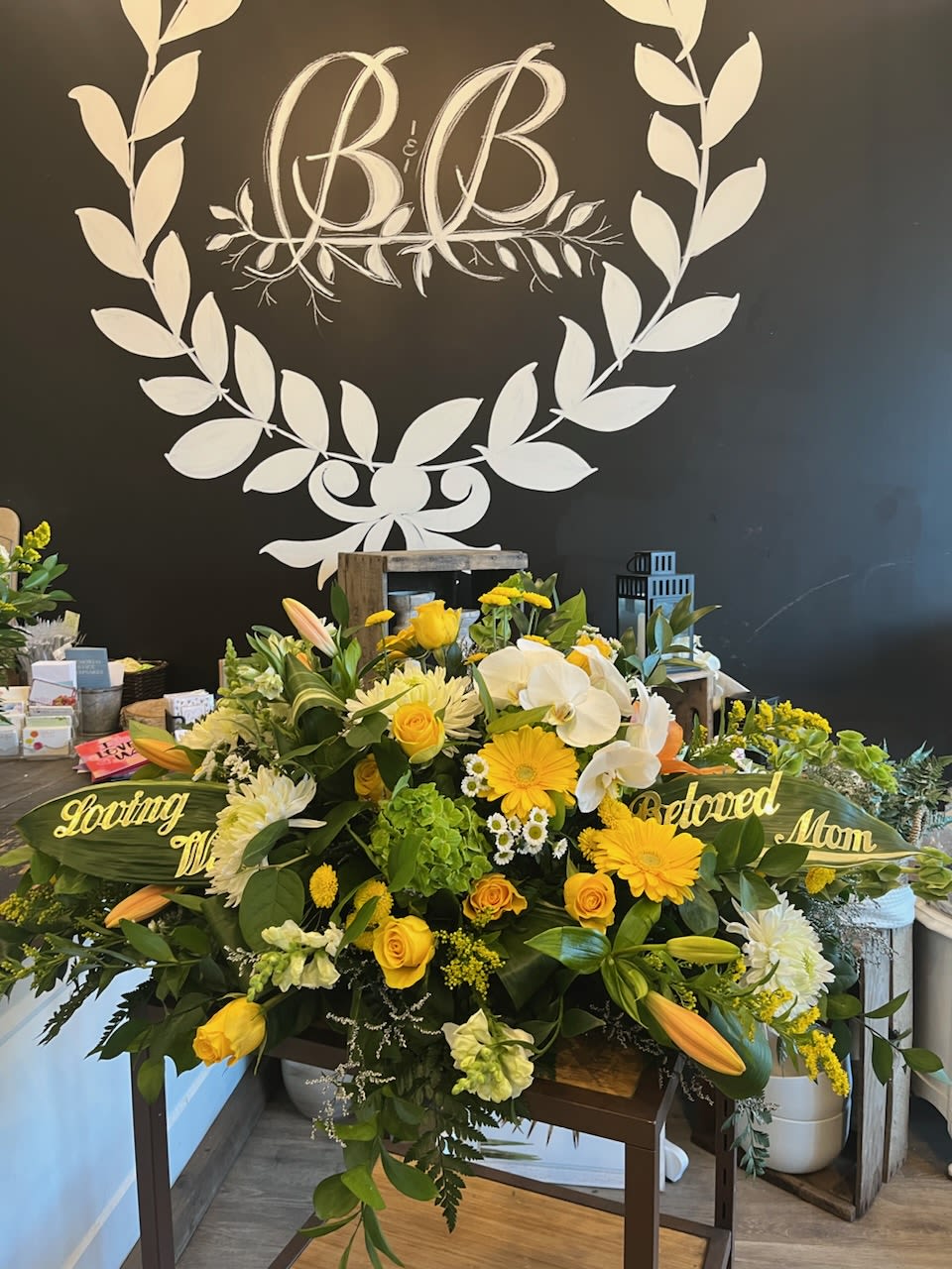 Yellow and white sympathy floral arrangement with roses, lilies, and orchids