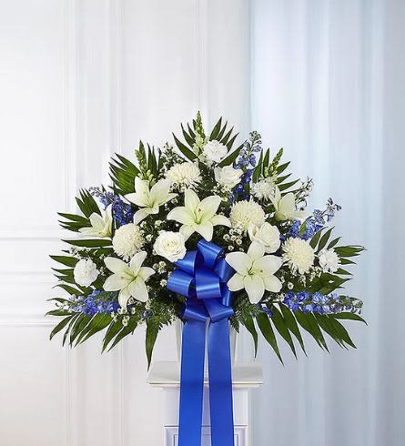 Heartfelt Sympathies Blue Standing Basket - Pet Friendly? No This arrangement contains Lilies, which are highly toxic to cats even in small amounts (pollen or water). It also includes Mums and Eucalyptus, which can irritate household pets.  Keep this display on its intended high easel and away from curious animals.   Human Allergy Note : This arrangement is pollen-heavy due to the Lilies and Mums. To reduce sneezing or staining, we recommend carefully snipping the yellow anthers from the center of the lilies as they open. Keep the area well-ventilated.  Care &amp; Longevity : As this is a basket arrangement, the flowers are tucked into water-retaining floral foam. To keep it fresh, gently pour a cup of water into the center of the basket daily to keep the foam saturated.   Best Occasions &amp; Situations : - Funeral service centerpiece - Church memorial tribute - Celebration of life ceremony - Graveside service accent - Funeral home visitation - Expression of deep sympathy  Why Customers Love It : - Stately Presence: The tall, fan-shaped design ensures it is visible even from the back of a large chapel. - Symbolic Colors: The blue and white palette represents peace, purity, and eternal calm. - Ready for Display: Arrives pre-arranged in a basket, making it easy for funeral directors to place on an easel. - Textural Variety: A beautiful mix of spiked, round, and ruffled blooms for a lush, premium feel.