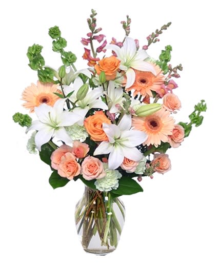 Peach and white flower bouquet in a clear glass vase