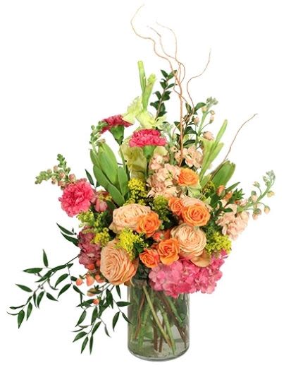 Mixed bouquet of peach, pink, and orange flowers in a glass vase