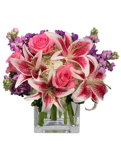 Pink roses and stargazer lilies in a clear square vase