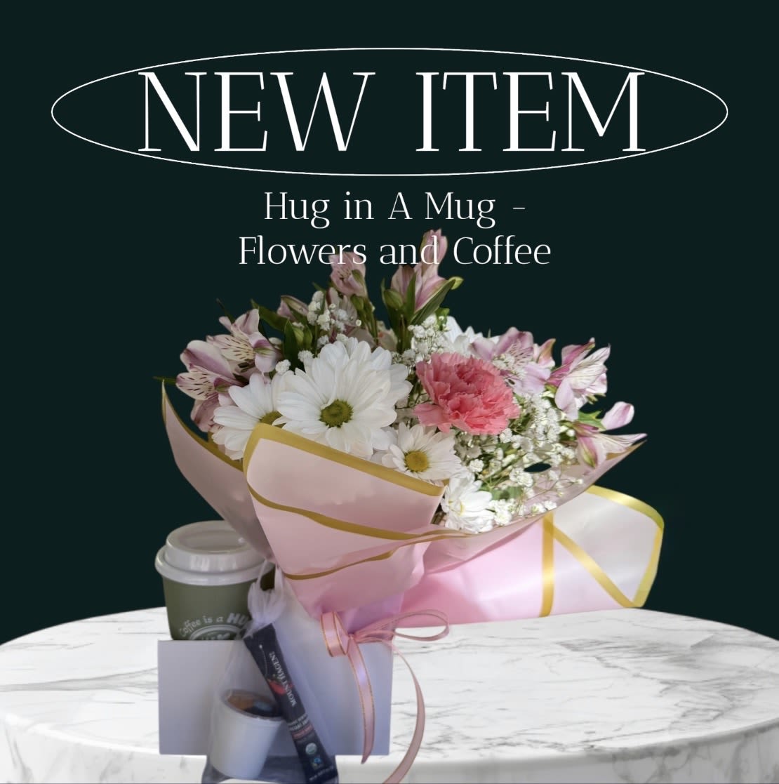 Bouquet of pink and white flowers with a coffee cup and gift items