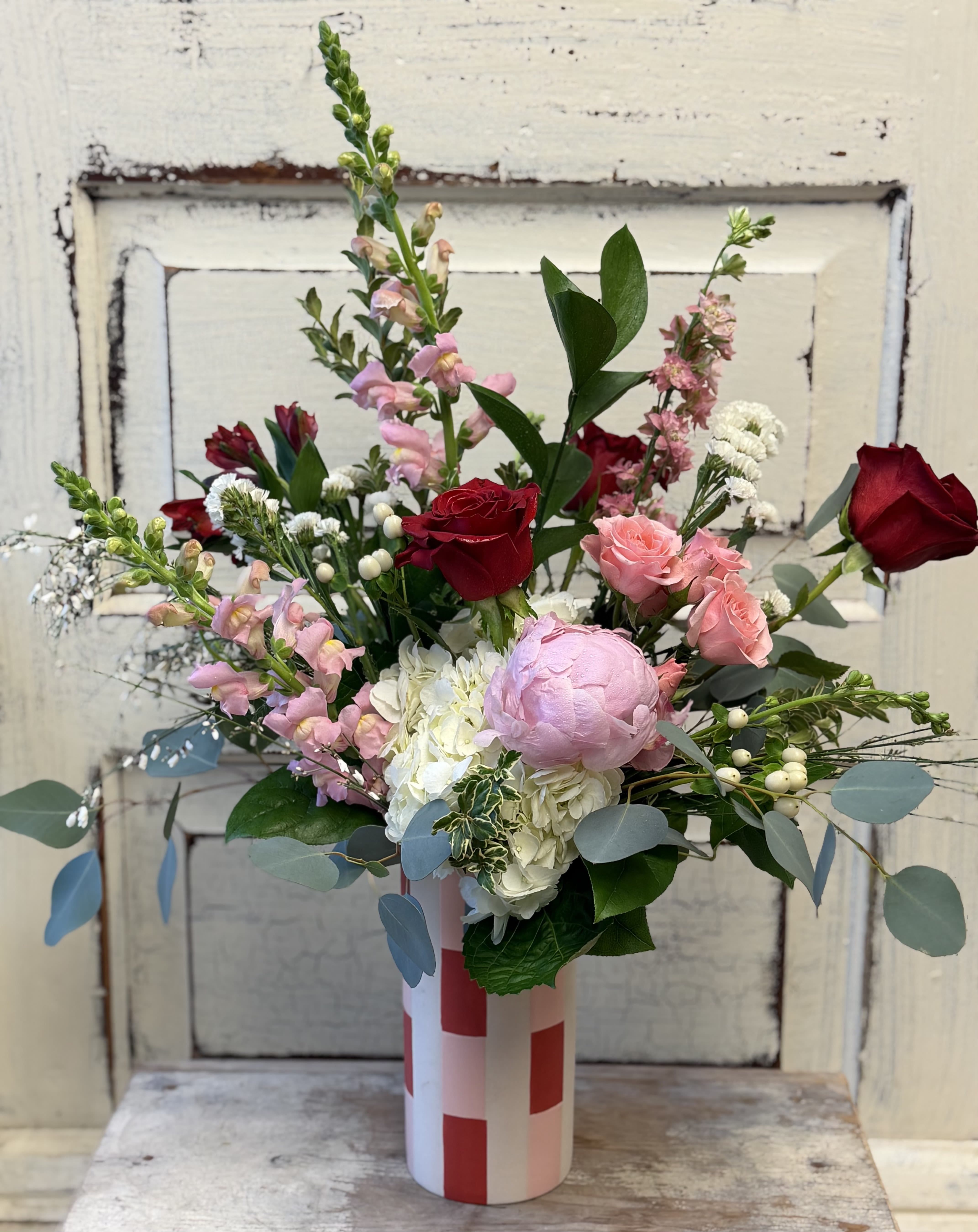 Mixed bouquet of pink and red roses in a striped vase