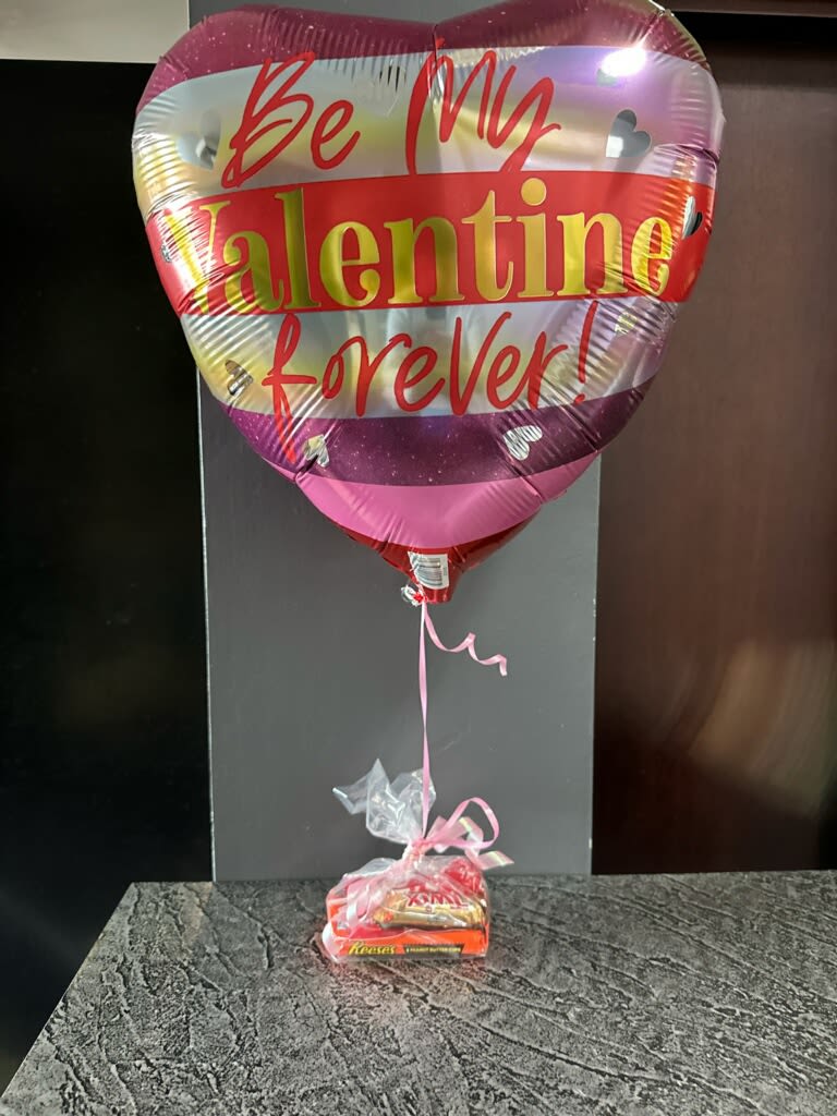 Heart-shaped Valentine balloon with a candy gift bundle below