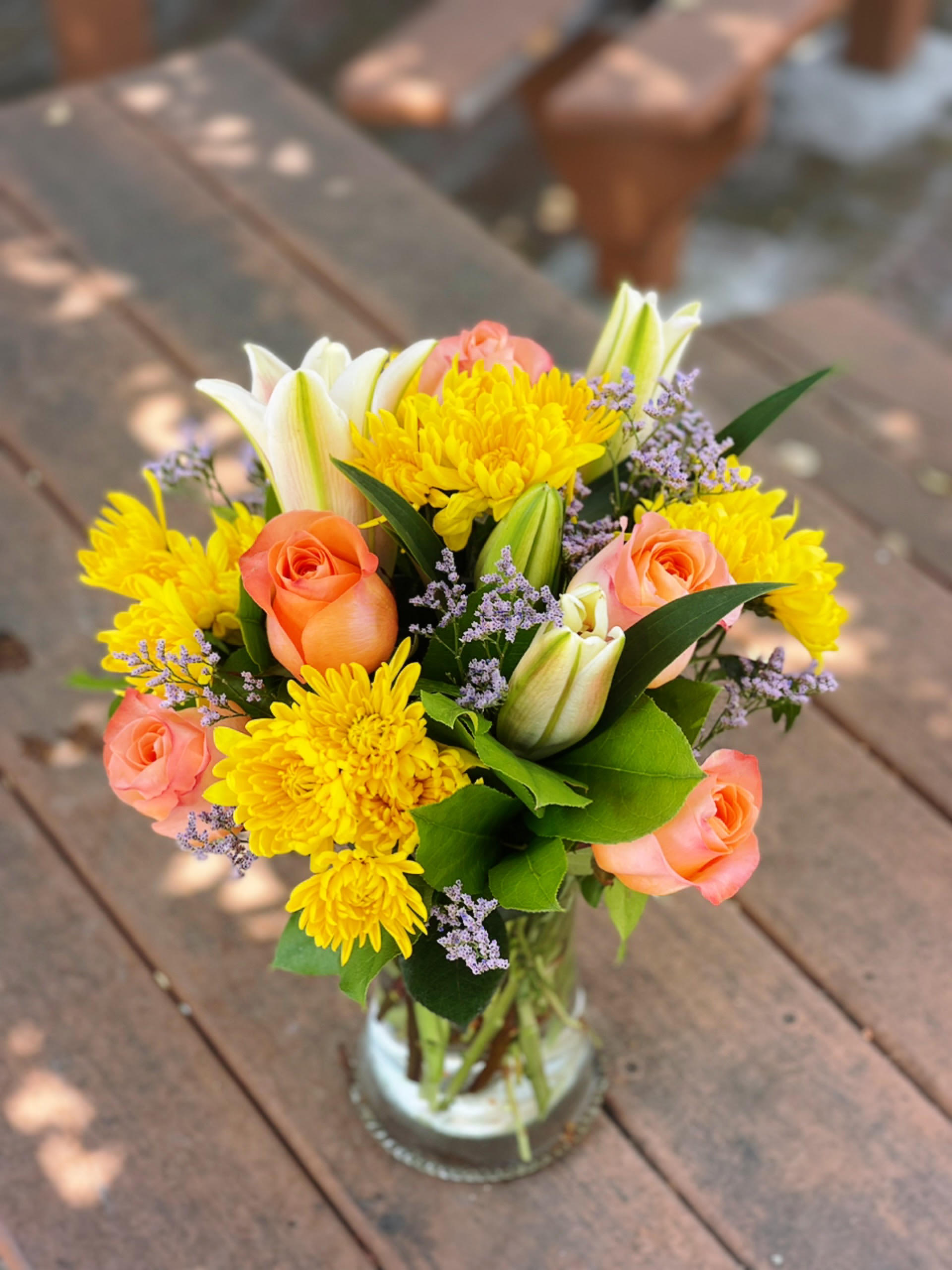 Weekly Special Arrangement 3 - - 2 Stems Pink Lilies - 6 Stems Orange Roses - 4 Stems Yellow Cushion (or Daisies) - Fillers - Greenery - 8 inches Gathering Vase