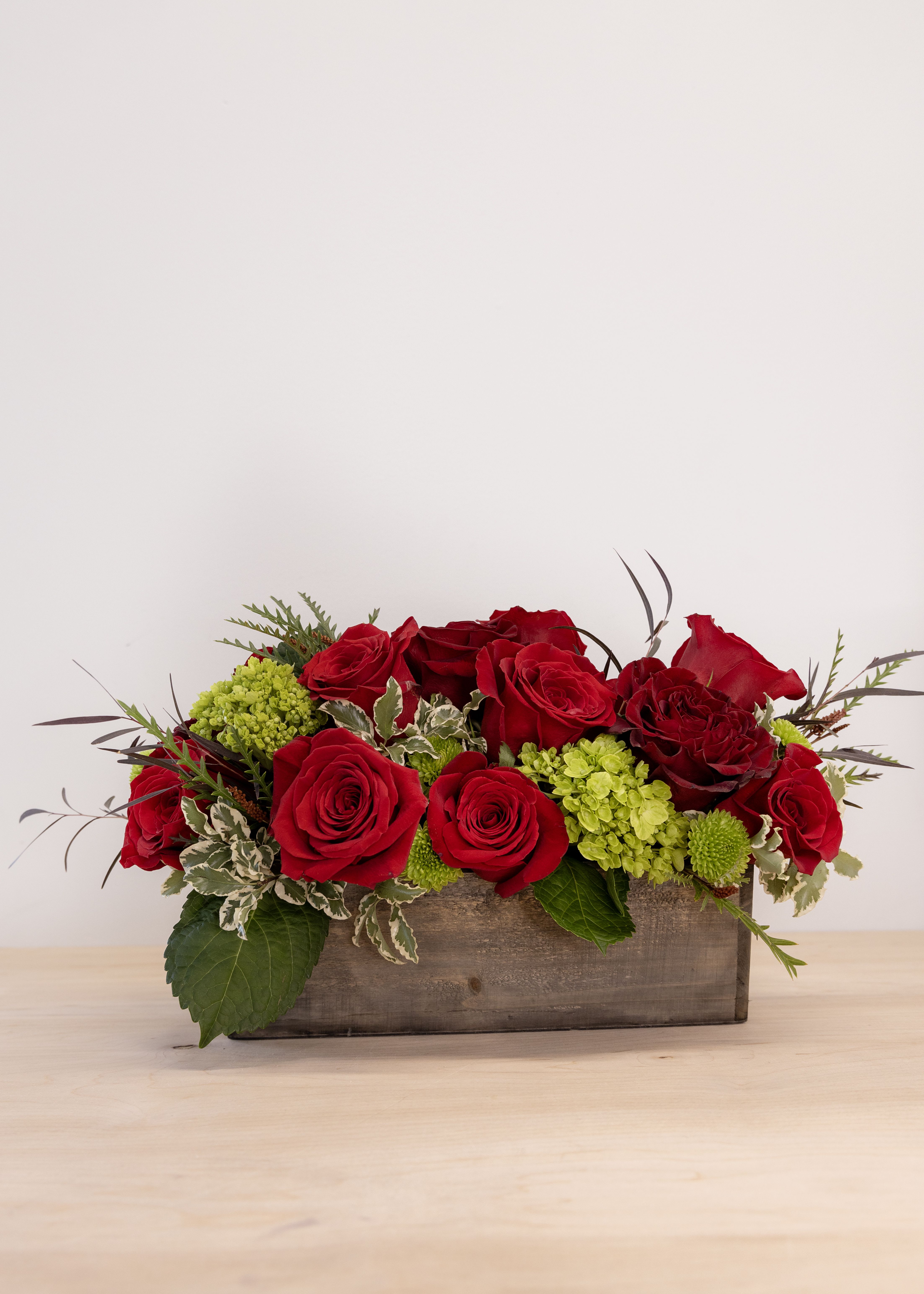Be Mine - This isn't your classic dozen roses!  Artful design in a wooden crate, the standard comes with a full dozen roses, mini mojito hydrangea, silver pittosporum, and lime green button mums.