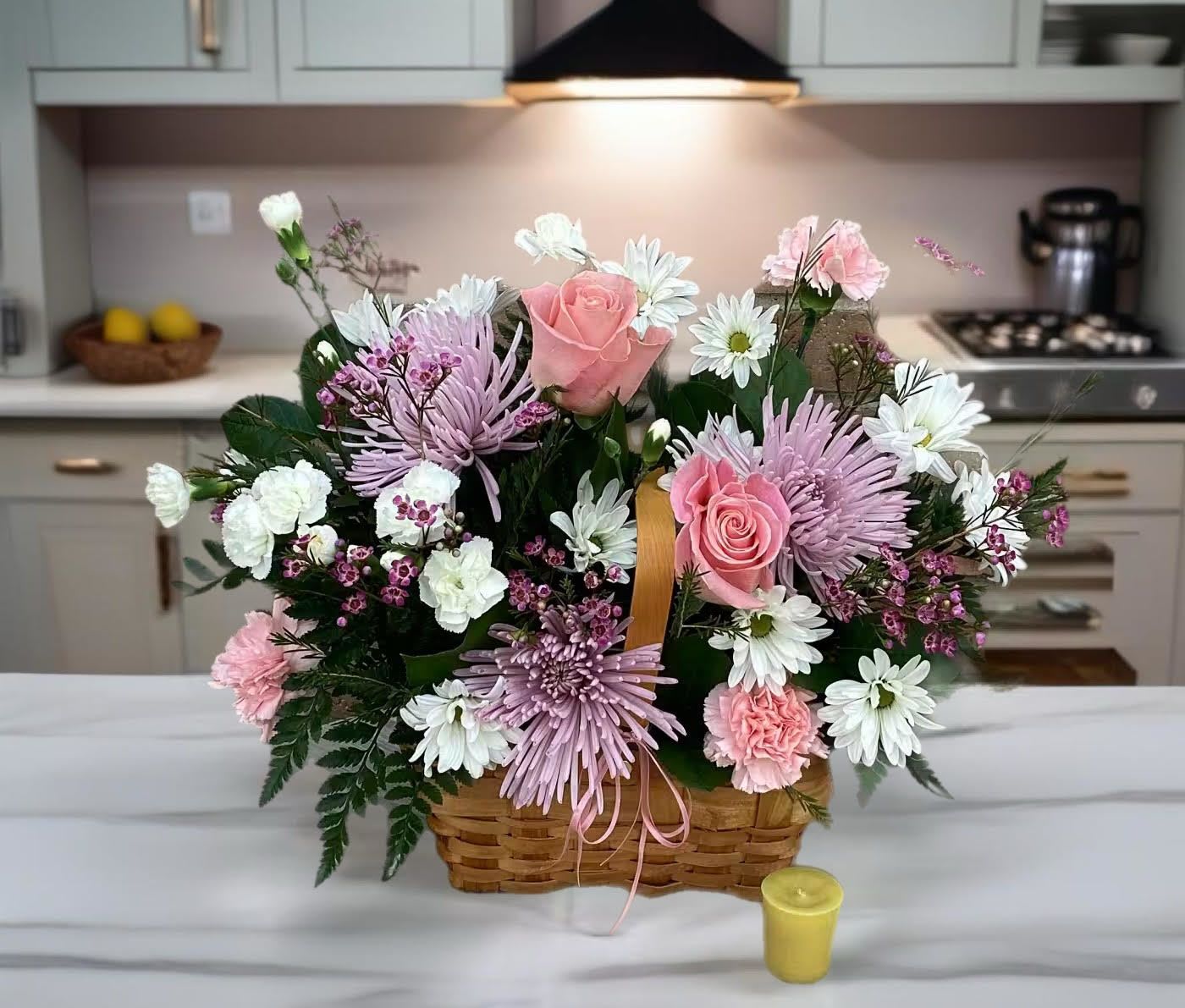 Basket arrangement of pink roses, white daisies, and lavender mums