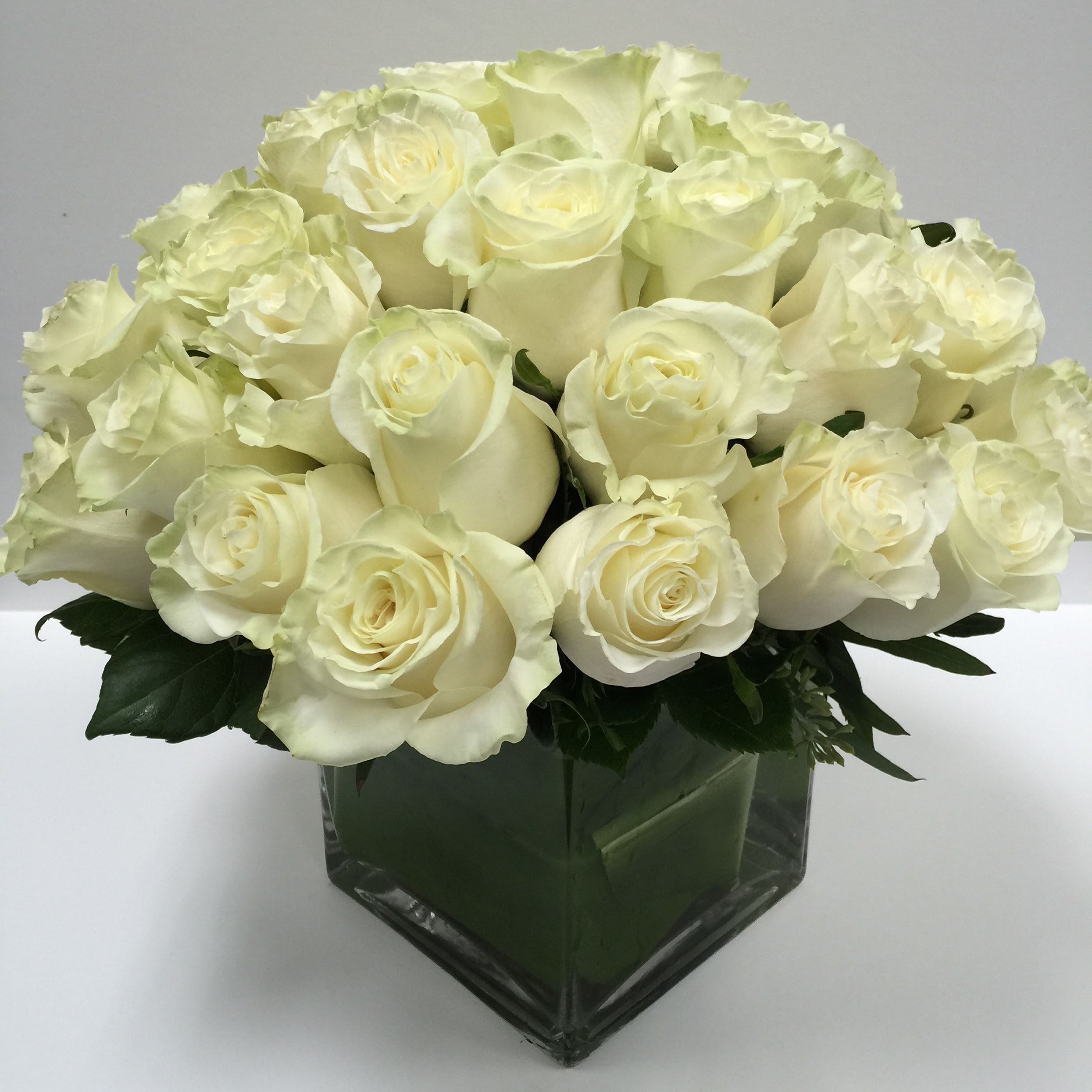 Bouquet of white roses in a square glass vase