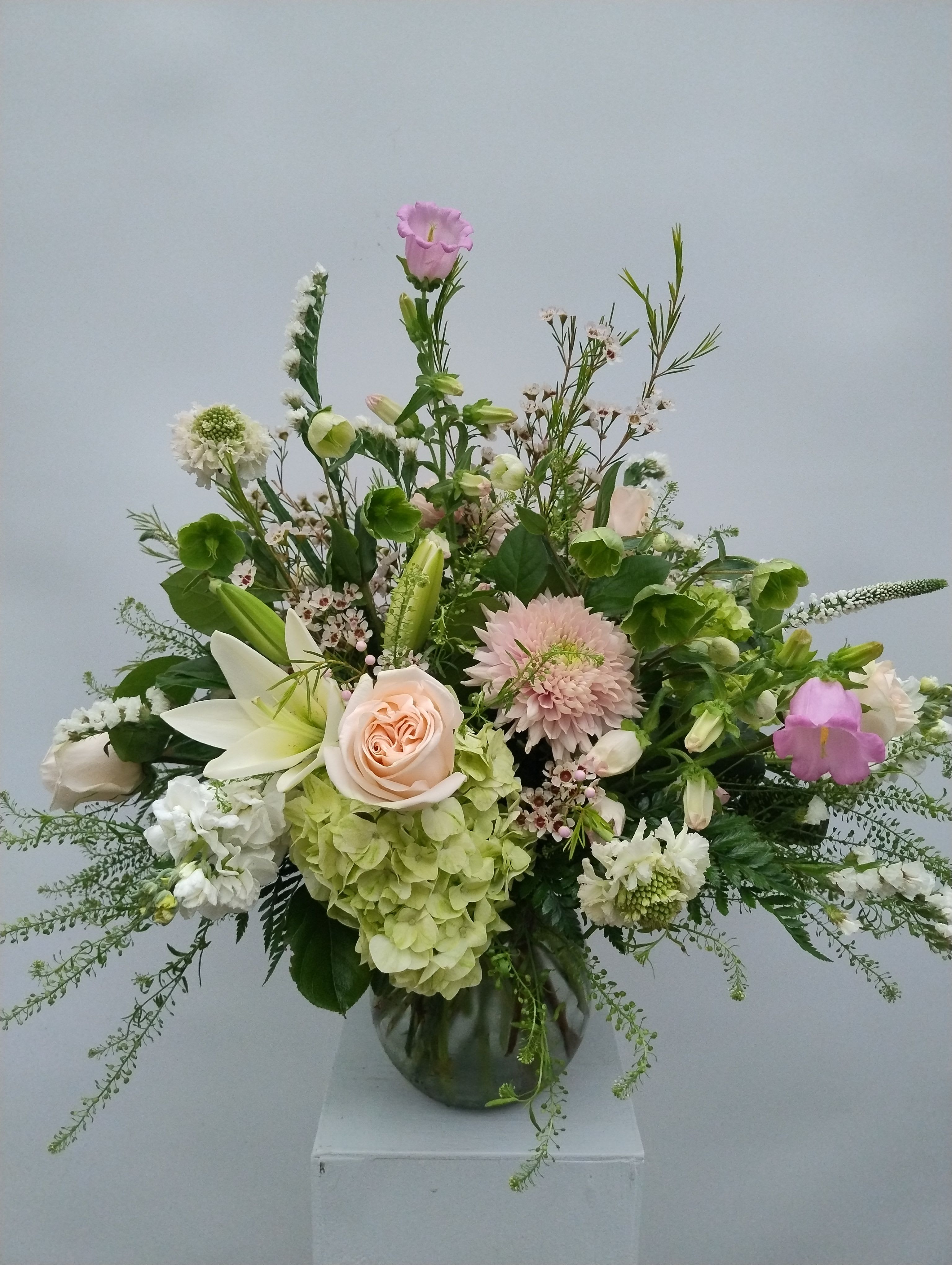 Mixed pastel flower arrangement in a glass vase