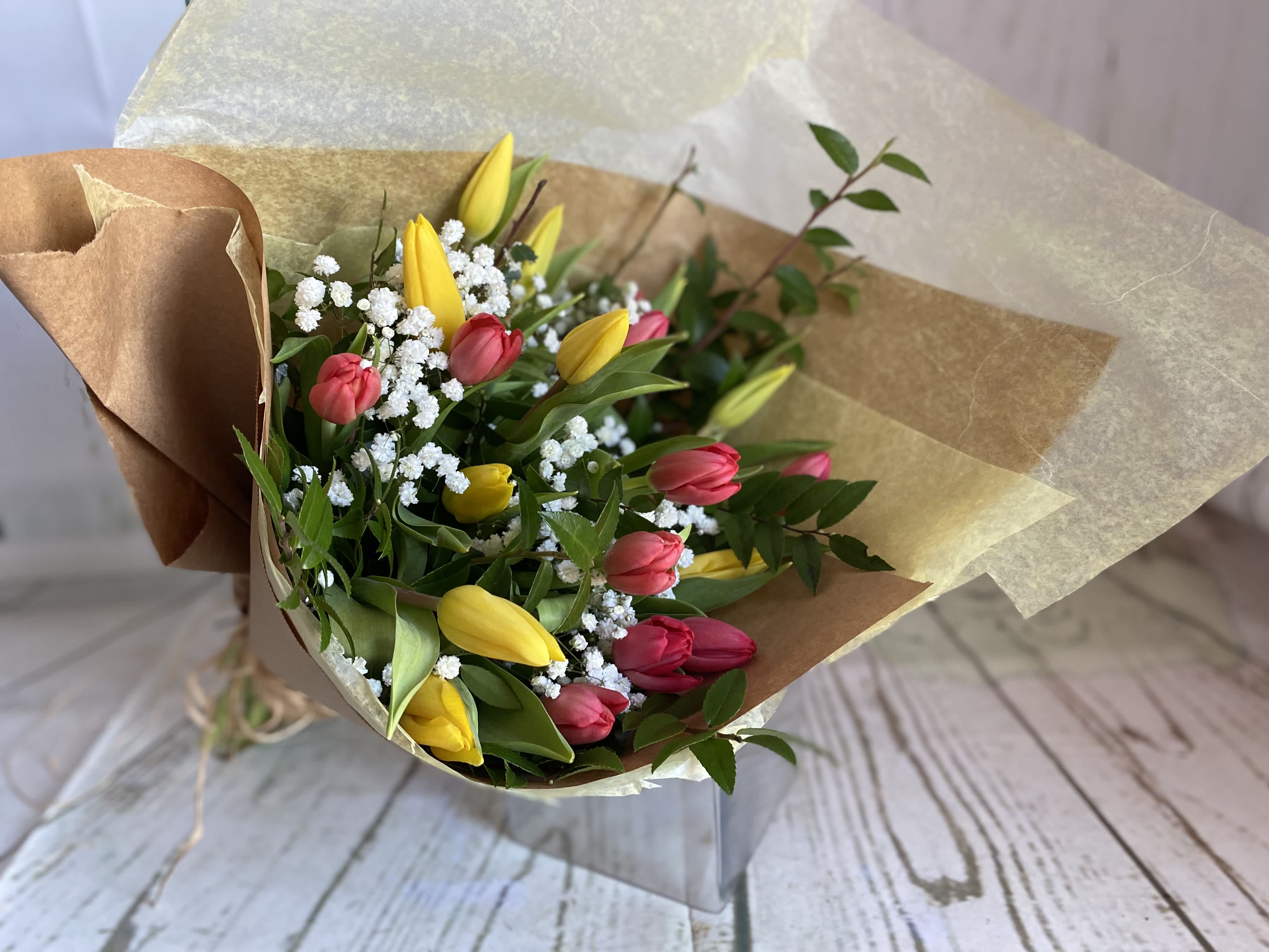 Bouquet of yellow and pink tulips with white filler flowers