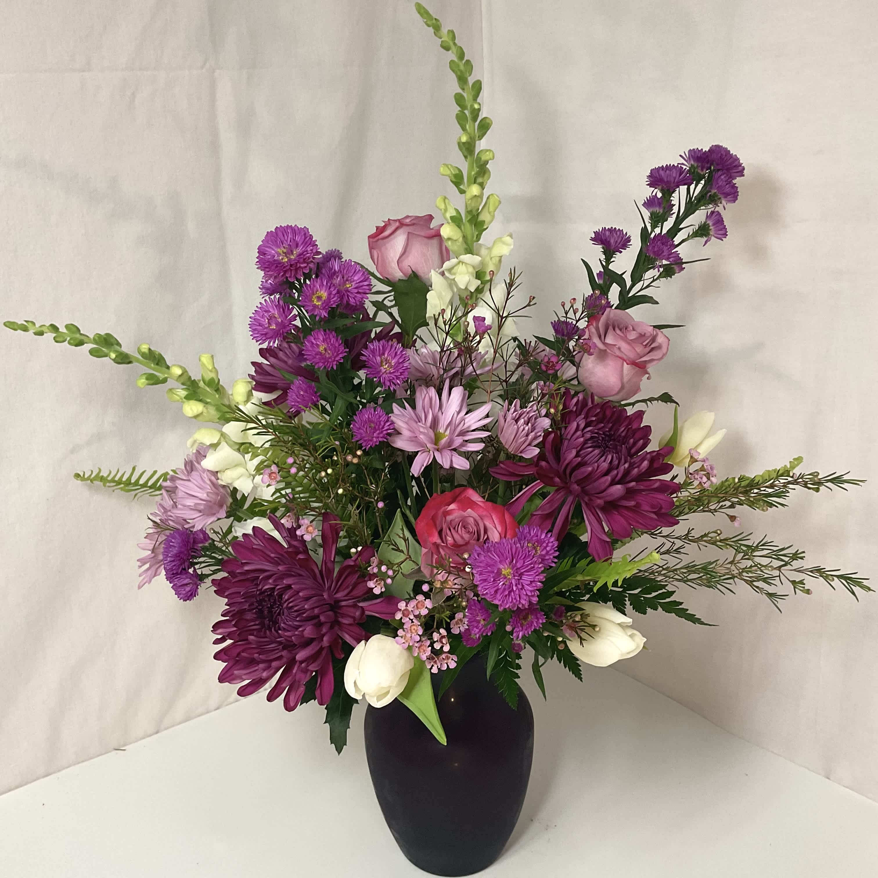 Oh, That’s Beautiful! - A captivating blend of lavender, purple, and white flowers, elegantly presented in a vibrant purple vase. The thoughtful selection of blooms creates a stunning interplay of colors and textures, exuding charm and tranquility. Perfect for brightening any setting, this arrangement serves as a lovely centerpiece or heartfelt gift, effortlessly bringing a touch of beauty and elegance to special moments.