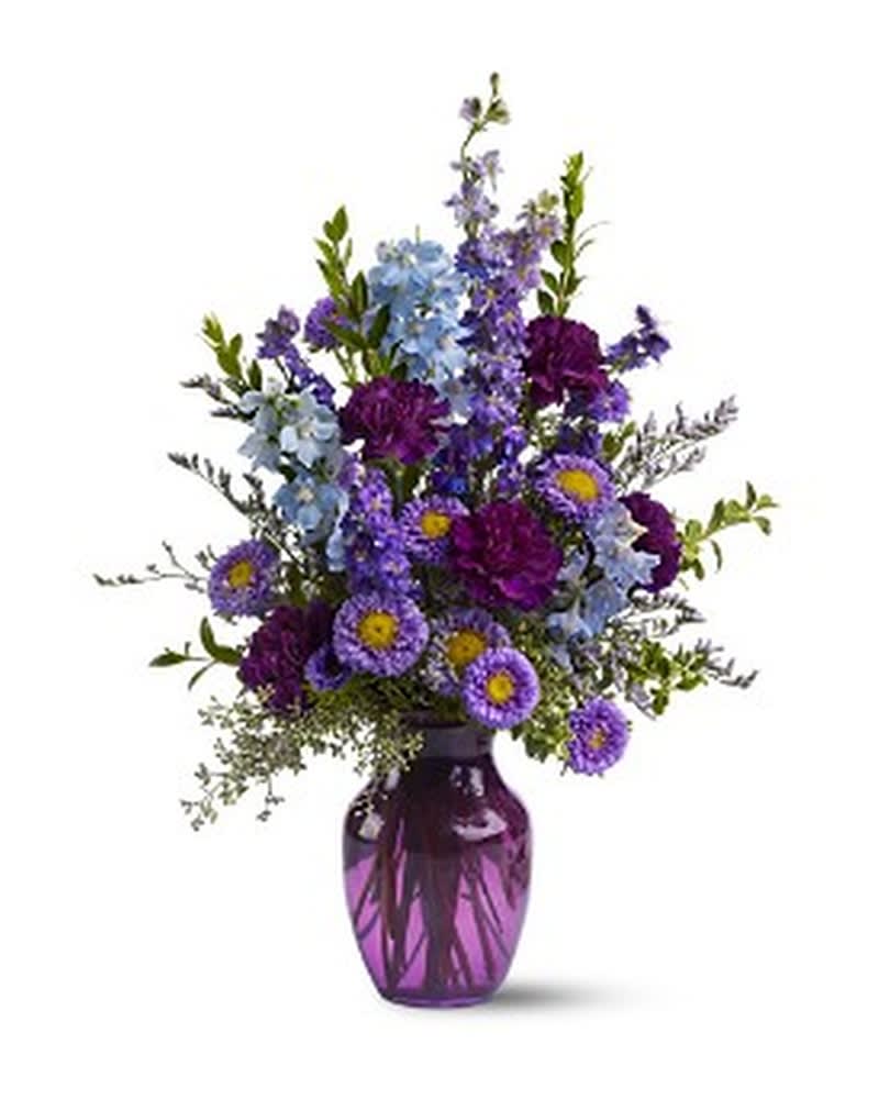 Purple and blue mixed flowers in a purple glass vase
