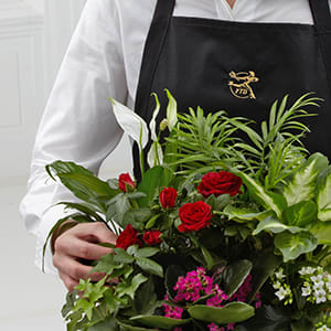 Person holding a bouquet of red roses and white calla lilies