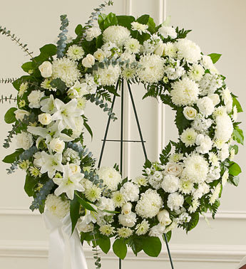 Serene Blessings White Standing Wreath - Sometimes, finding the words to show how much a loved one will be missed can be very hard. When you select this standing wreath of all-white flowers, expertly designed and crafted by one of our local florists, you are sending an arrangement that reflects all of the respect, love and compassion you want to express during this difficult time. Standing wreath arrangement of fresh white flowers such as roses, football mums, carnations and more Accented by spiral eucalyptus, salal and more Appropriate for family, friends and business associates to send directly to the funeral home Our florists use only the freshest flowers available,so assortment may vary 