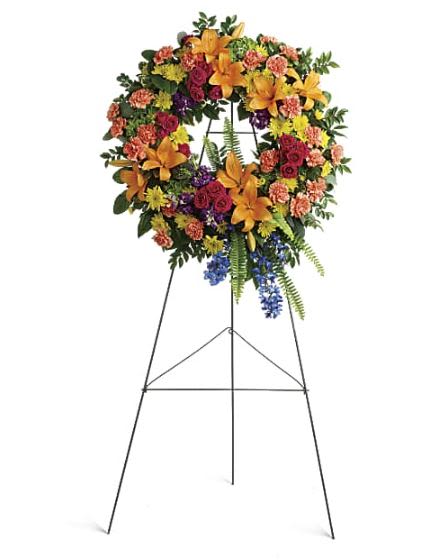 Colorful Serenity Wreath -  Pet Friendly? No . This arrangement contains Asiatic Lilies, which are highly toxic to cats, and Chrysanthemums and Eucalyptus, which can irritate household pets.  Keep out of reach; avoid homes with curious cats or dogs.   Human Allergy Note : Warning: This arrangement contains pollen-heavy Lilies and Chrysanthemums.  To minimize irritation, keep the wreath in a well-ventilated area and avoid placing it near guests with known floral sensitivities.   Care &amp; Longevity : As this is a wreath set in floral foam, it requires consistent hydration to stay fresh. Gently mist the blooms daily and pour a small amount of water into the back of the foam ring every 24 hours to keep the stems hydrated. Avoid placing the easel in direct sunlight, near outdoor heat sources, or under localized vents.   Best Occasions &amp; Situations : - Funeral service or memorial - Celebration of life ceremony - Graveside service tribute - Church altar decoration - Military or public service honor - Anniversary of a loss (cemetery placement)  Why Customers Love It : - Radiant Color Palette: A beautiful “rainbow” mix that celebrates a life lived to the fullest. - Impressive Height: Standing 34 inches tall, it makes a grand and respectful statement at any service. - Ready for Display: Arrives pre-mounted on a professional wire easel for immediate placement. - Fresh Textures: Uses a diverse mix of premium blooms and lush Tennessee-style greenery.