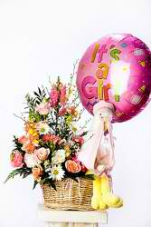Basket of mixed flowers with a pink "It's a Girl" balloon and teddy bear