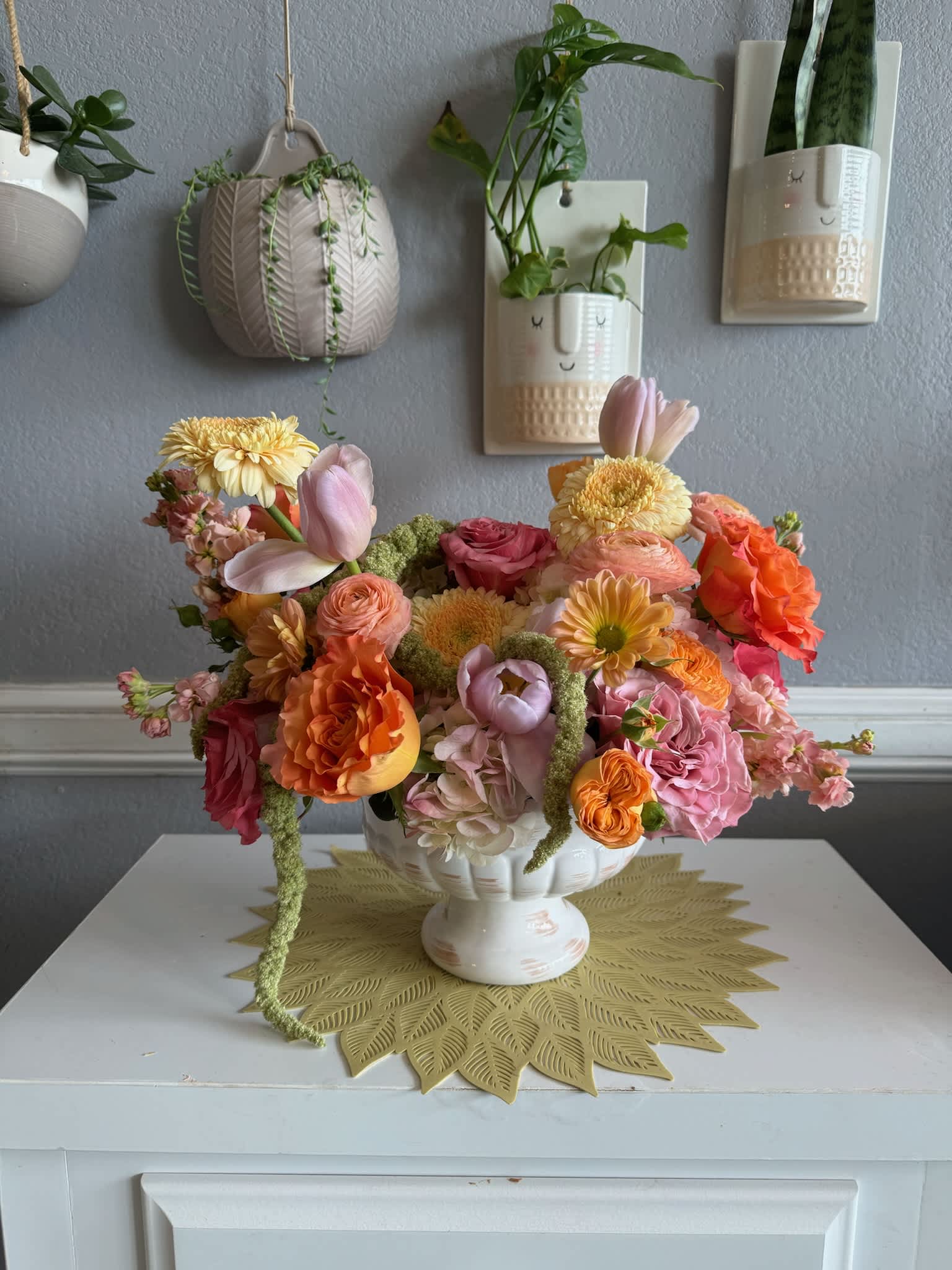 Colorful flower arrangement in a white pedestal bowl
