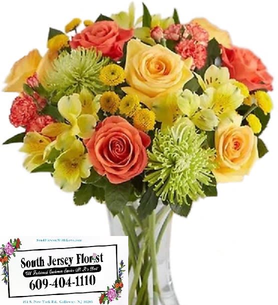 Mixed bouquet of roses and yellow flowers in a clear glass vase