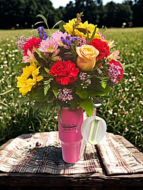 Mixed bouquet in a pink cup-style vase with a hanging tag