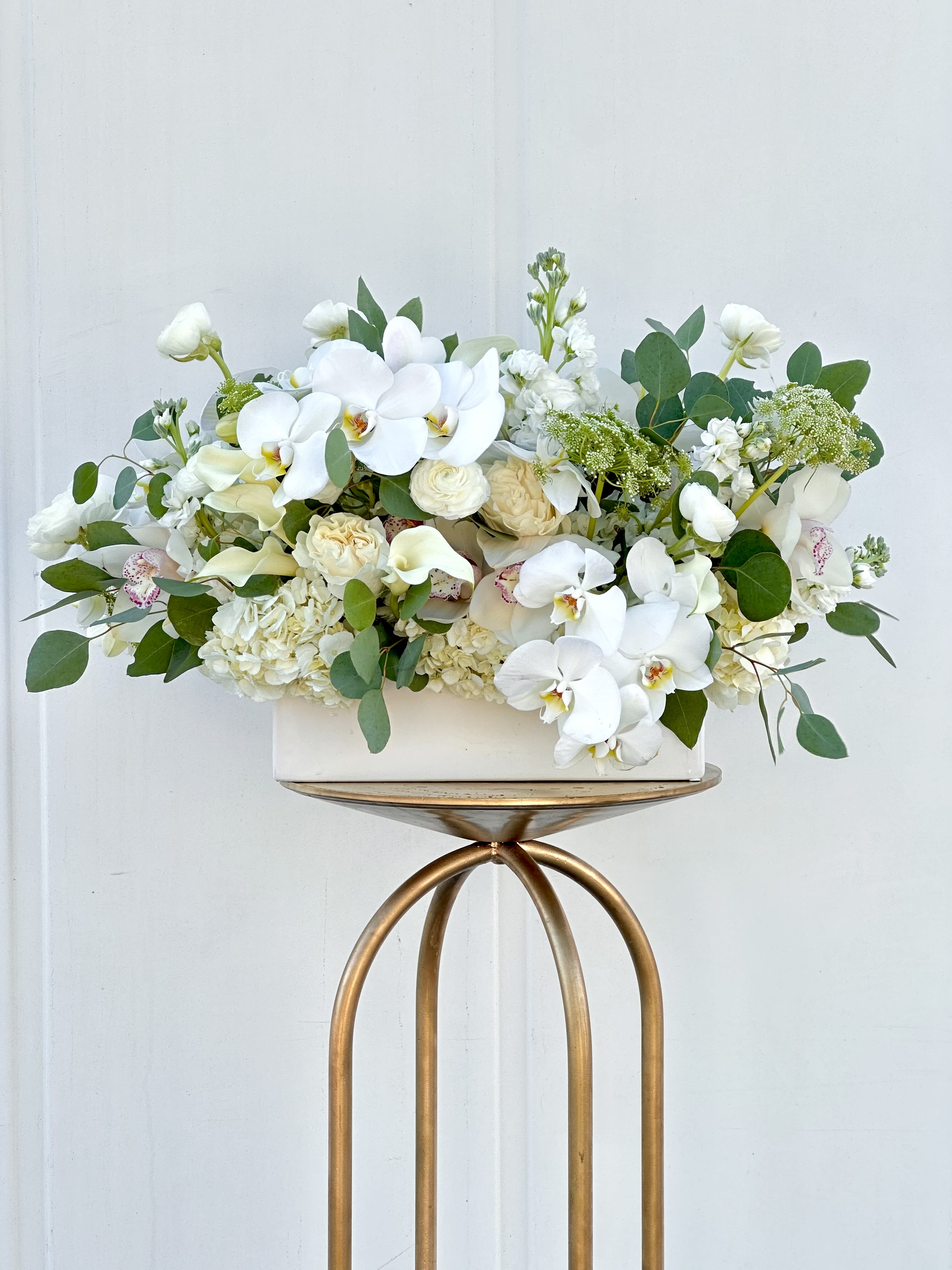 White orchid and rose arrangement in a rectangular vase