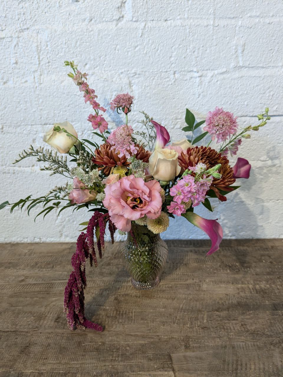 Mixed pink and cream floral arrangement in a glass vase