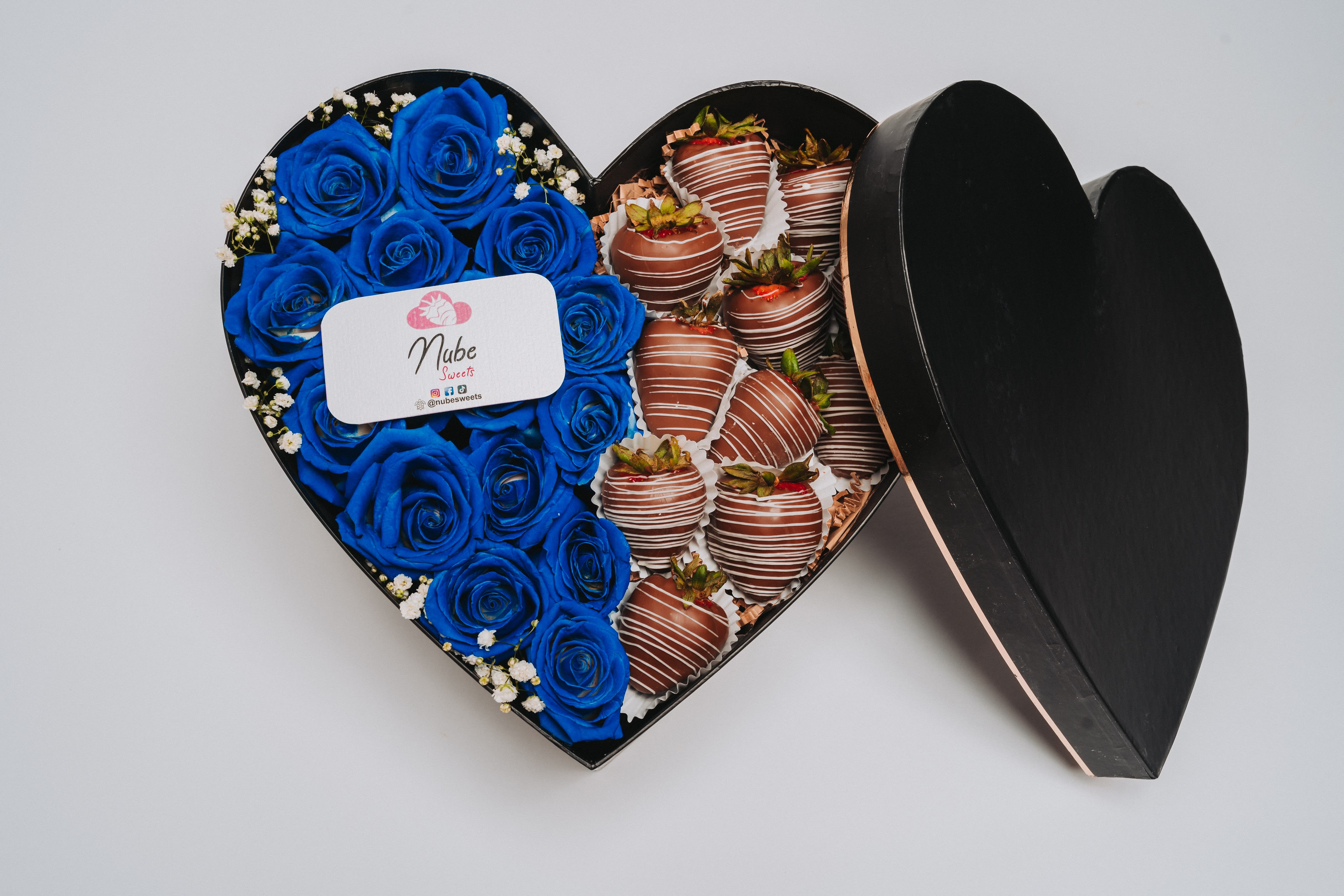 Heart-shaped box with blue roses and chocolate-covered strawberries