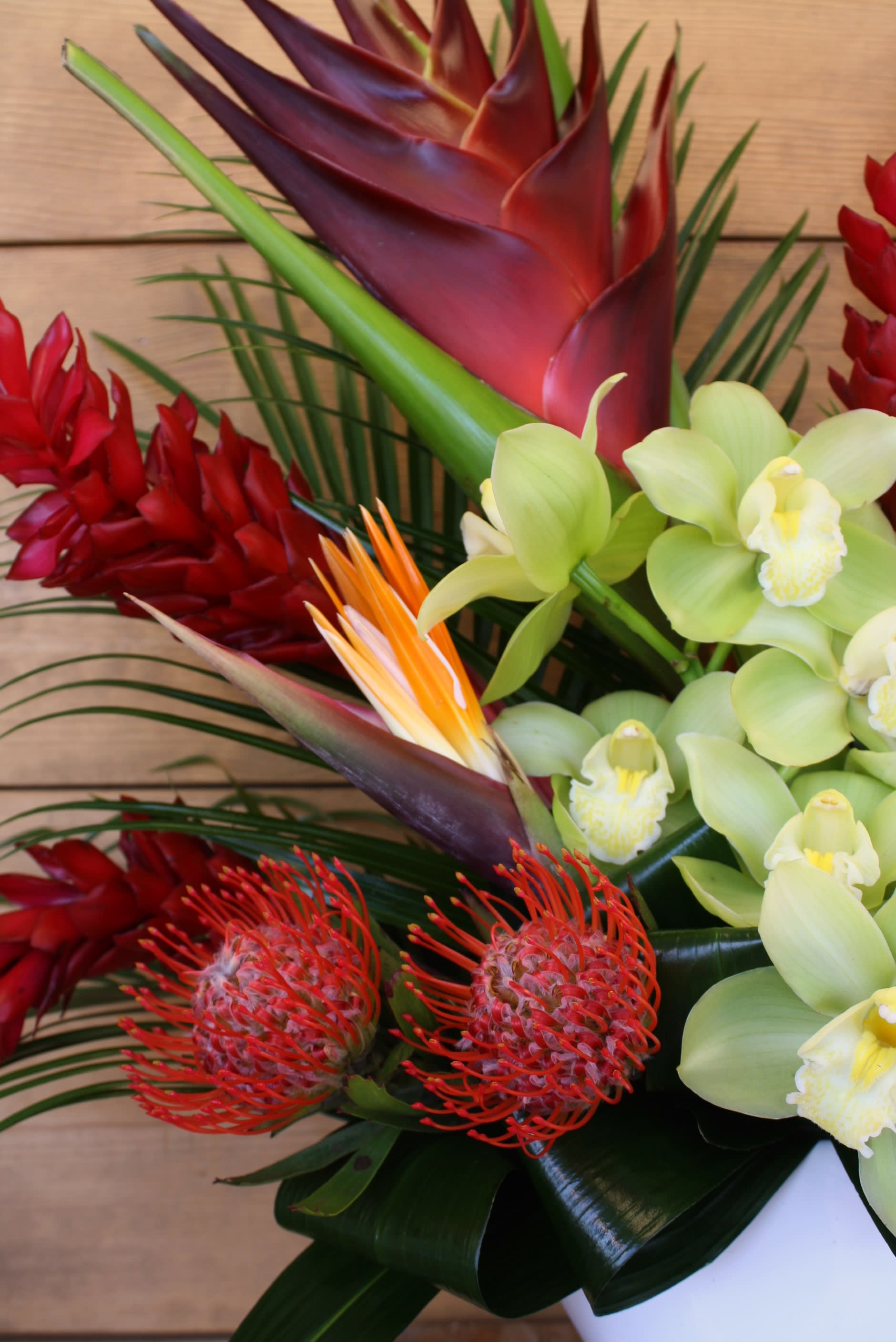 Tropical bouquet with red ginger, green orchids, and orange pincushion protea