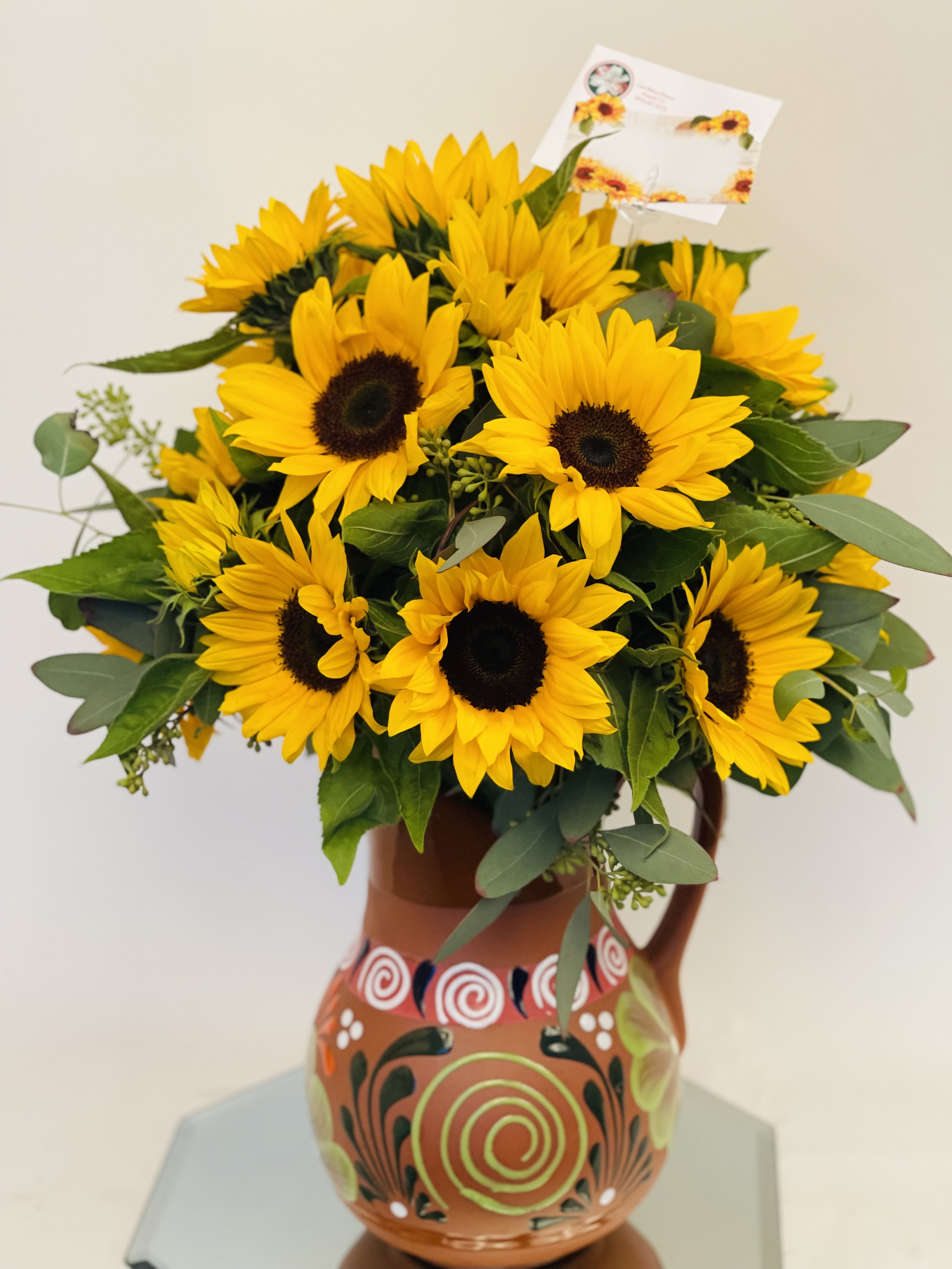 Sunflower bouquet in a painted ceramic pitcher