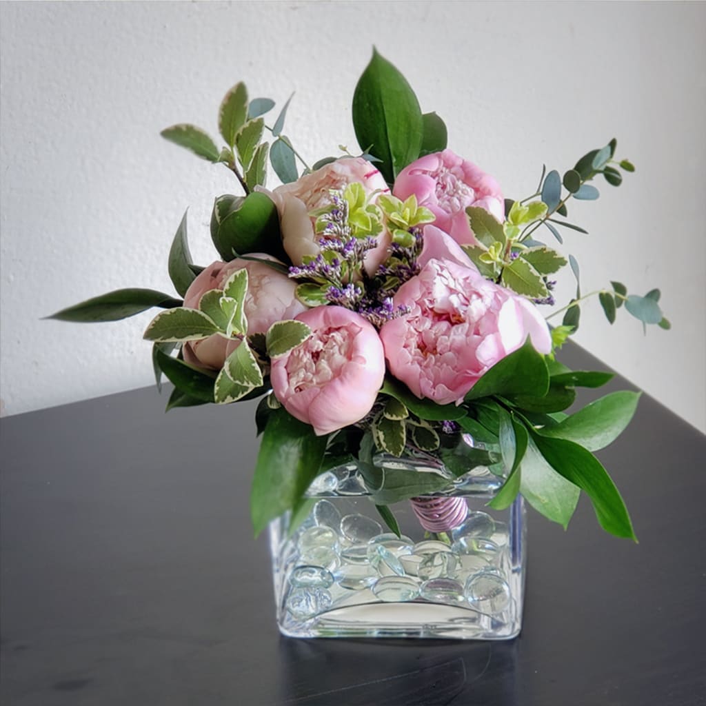 Bi-color Pink Peonies Bouquet - Bi-Color Pink Peony Bouquet - A Winter to Springtime Delight. Hand-tied and ready to enjoy, it is delivered in a chic square glass vase.   Perfect for birthdays, anniversaries, or to brighten someone's day, these exquisite blooms capture the essence of spring.  Approximately 8" H x 8" W, send these perfect blooms of fresh peonies for a thoughtful gift, a romantic gesture, or a sophisticated accent to any interior decor. 