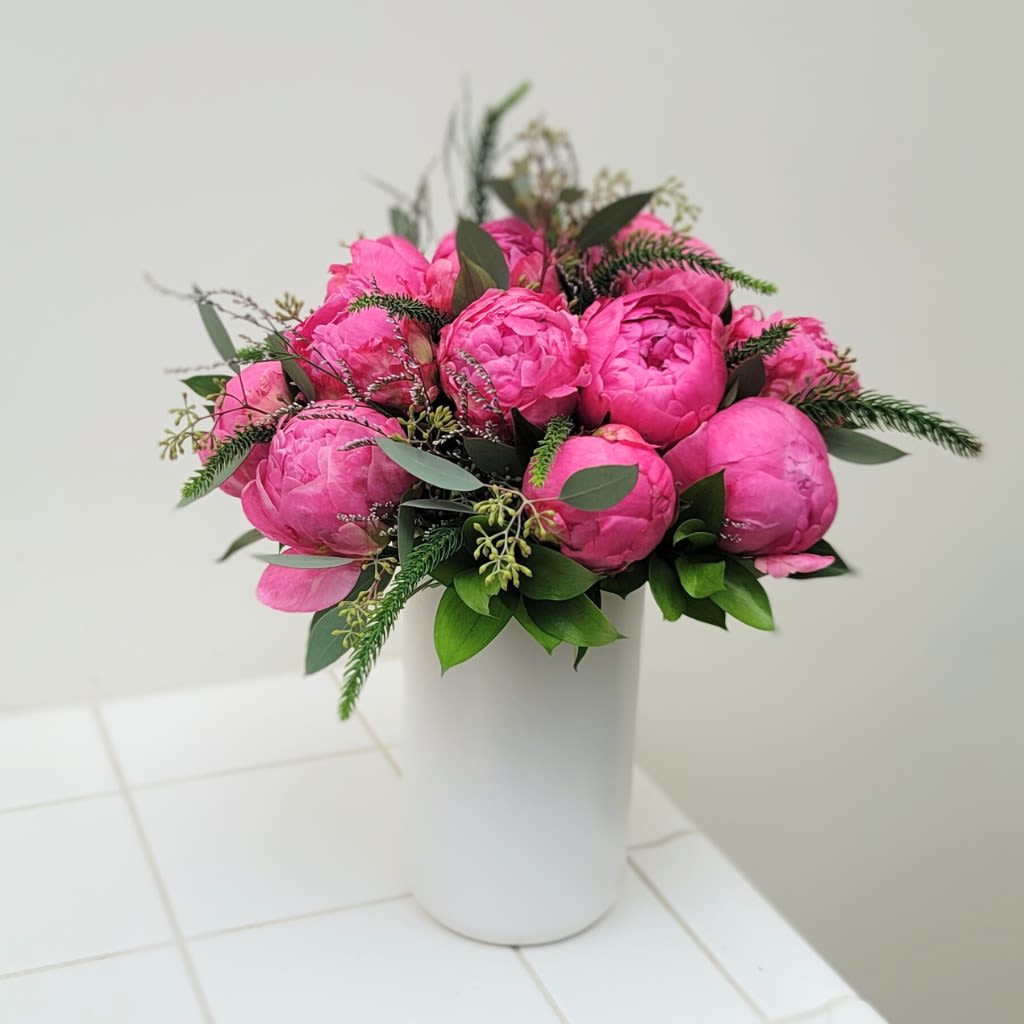 Pink peony bouquet in a white vase