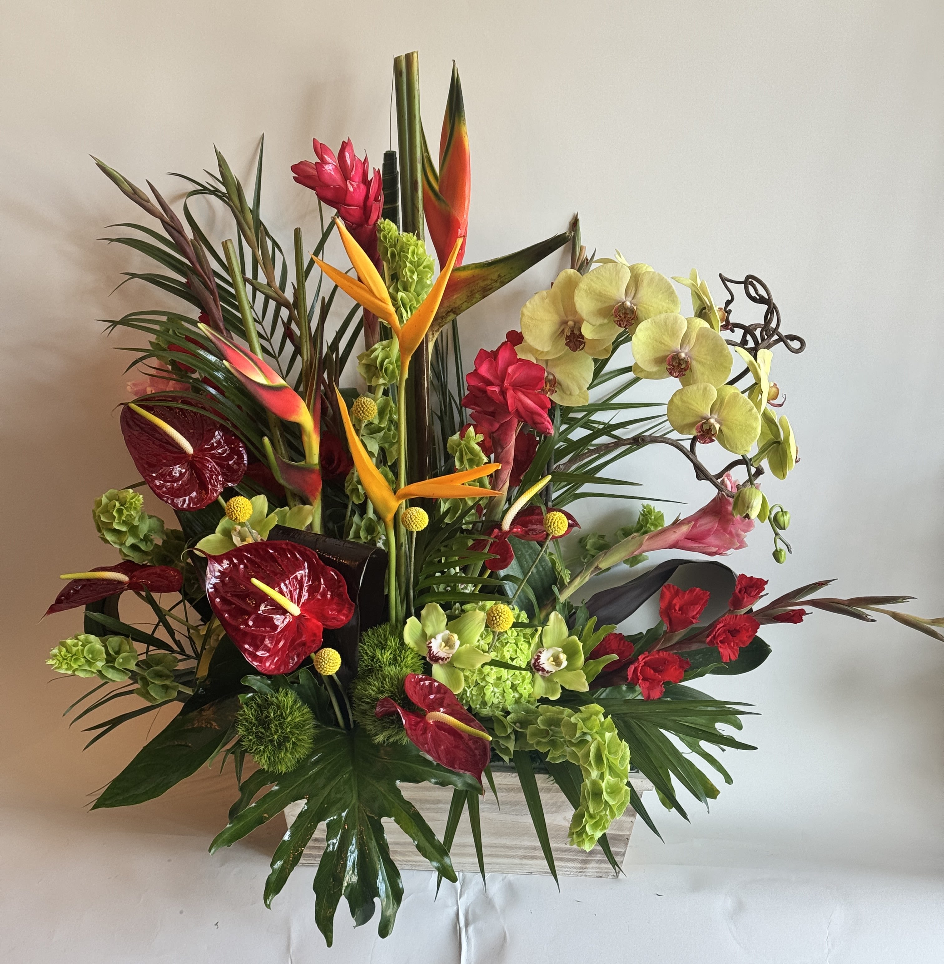 Tropical floral arrangement with orchids, anthuriums, and bird-of-paradise