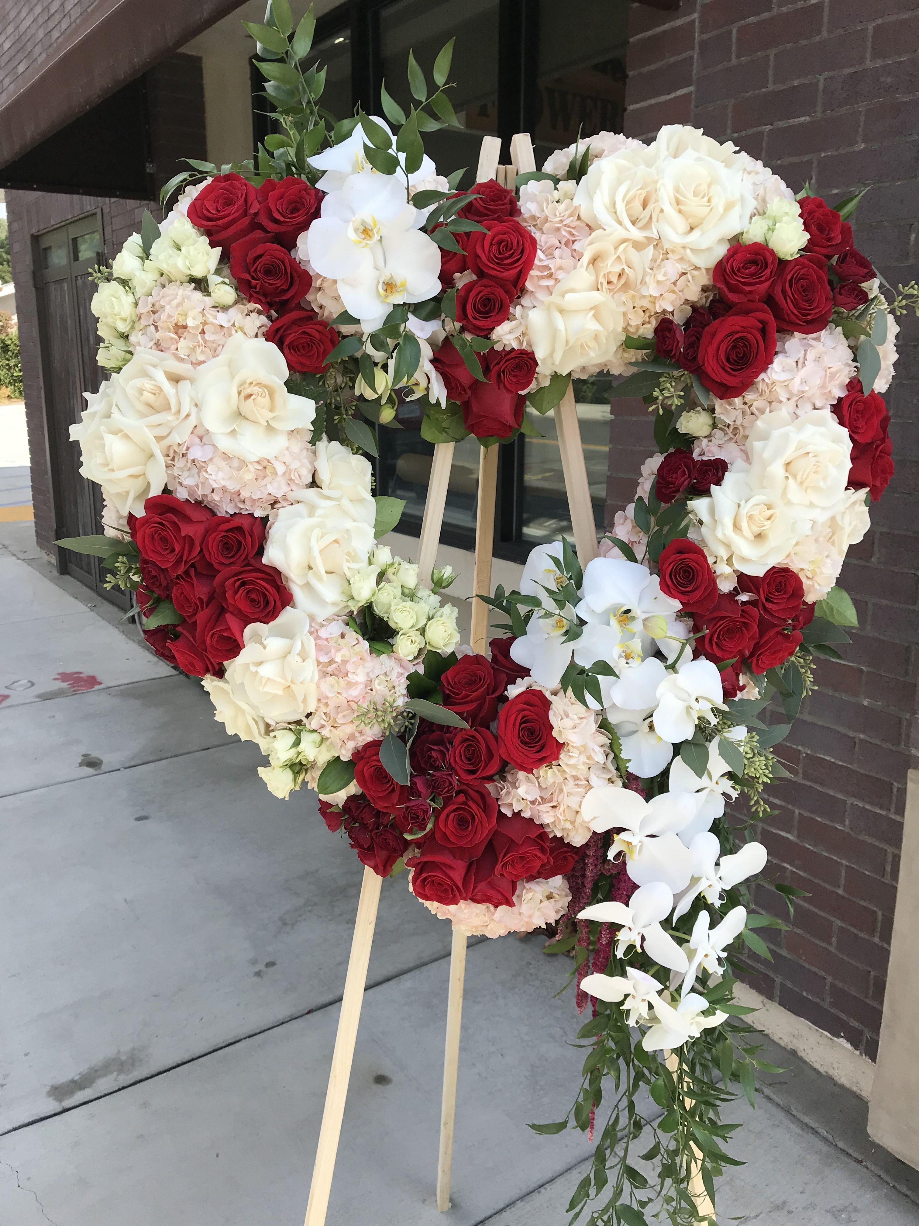 Sympathy Heart - Flowers: pink hydrangea, freedom red roses, white spray roses, white orchids, ivory reflexed roses, burgundy hanging Amaranthus, Italian ruscus, and seeded eucalyptus.
