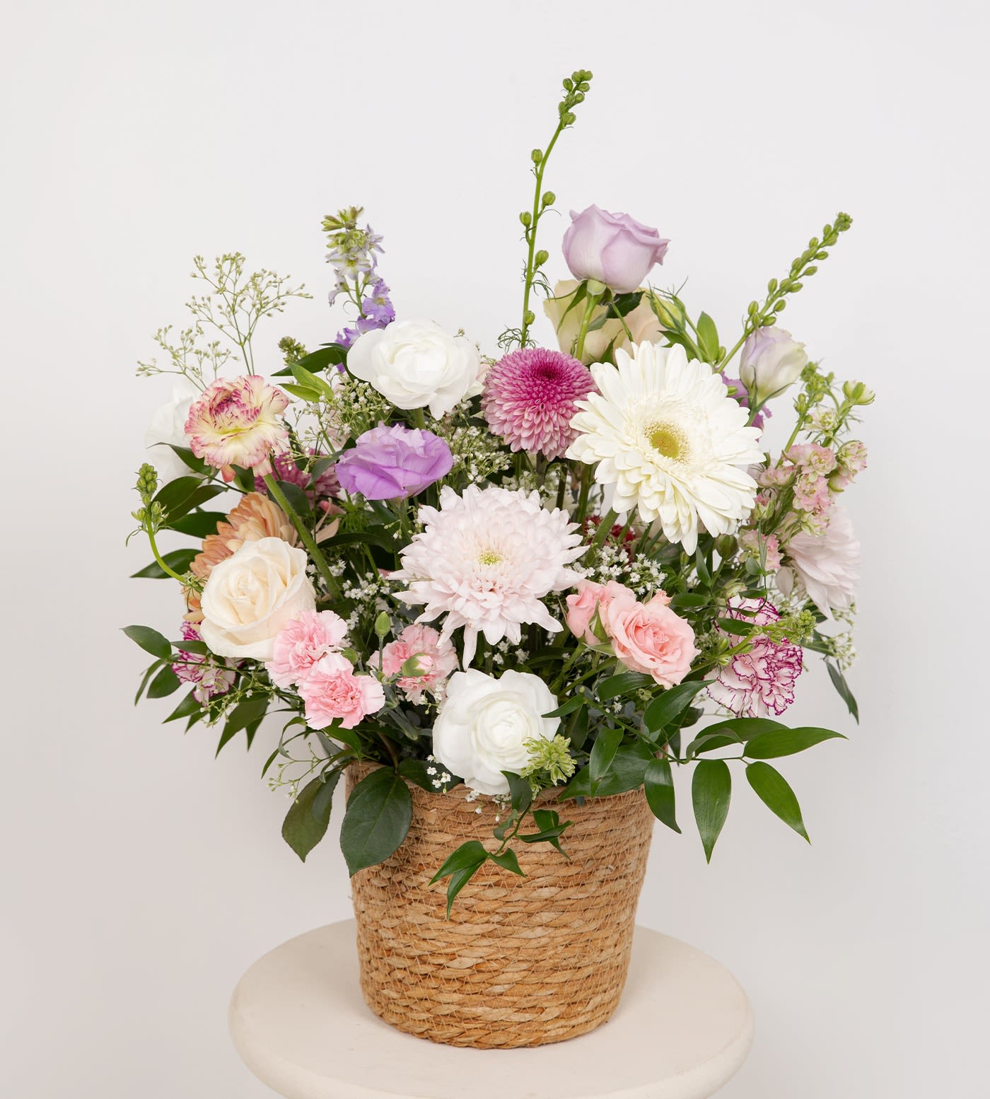 Mixed pastel flower arrangement in a woven basket