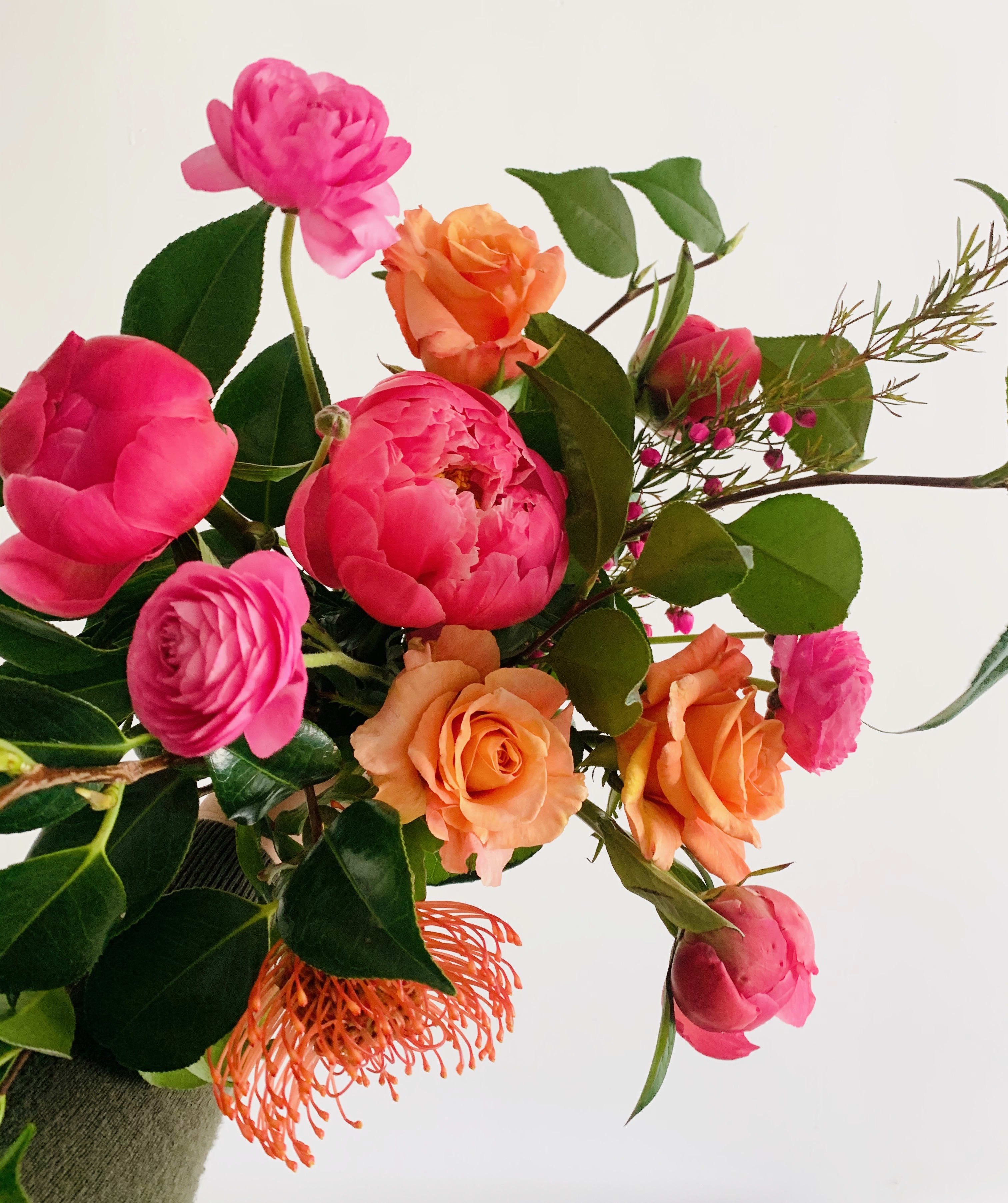 Bouquet of pink and orange roses with mixed greenery