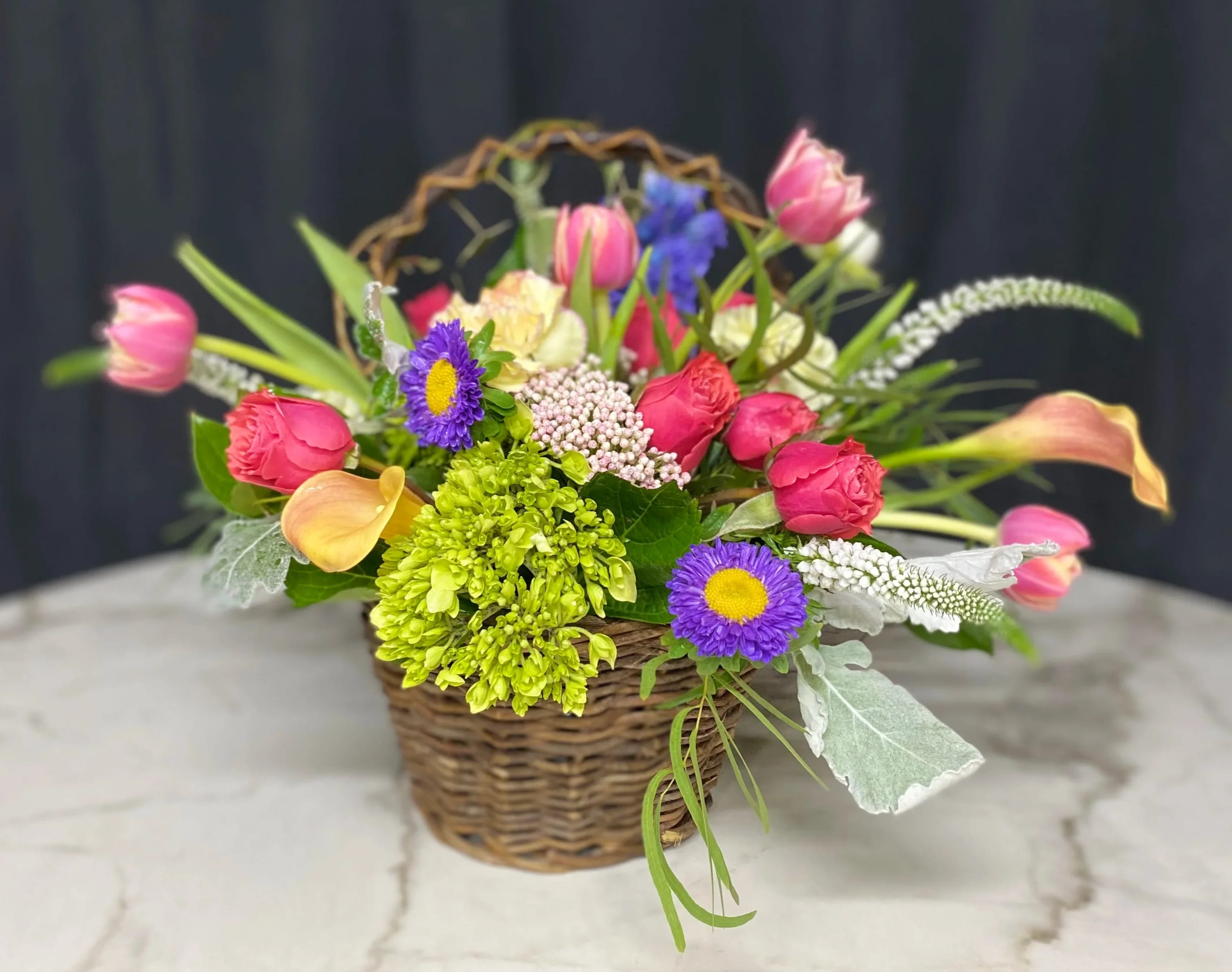 Colorful mixed flower arrangement in a wicker basket