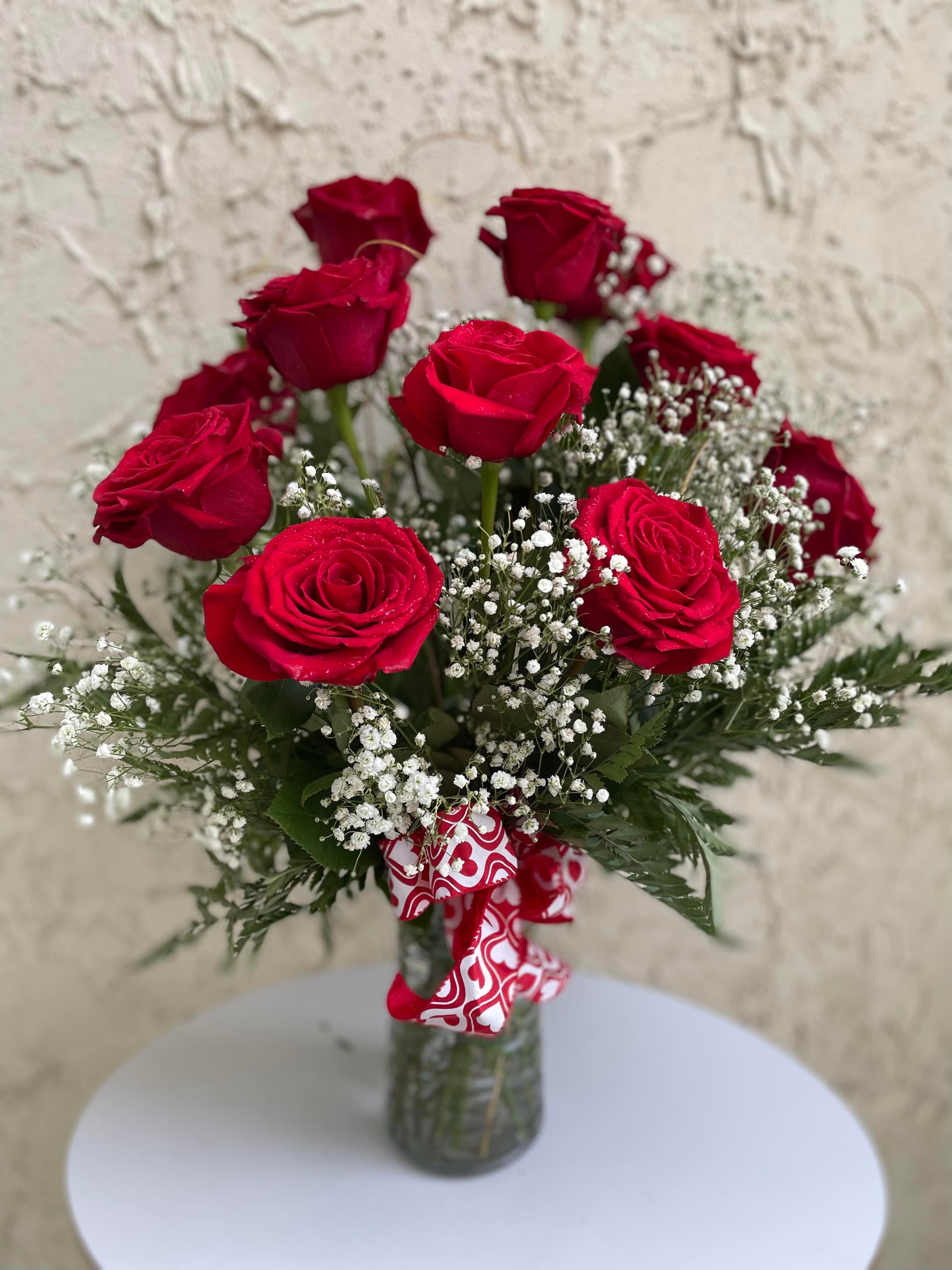 Bouquet of red roses with baby's breath in a glass vase