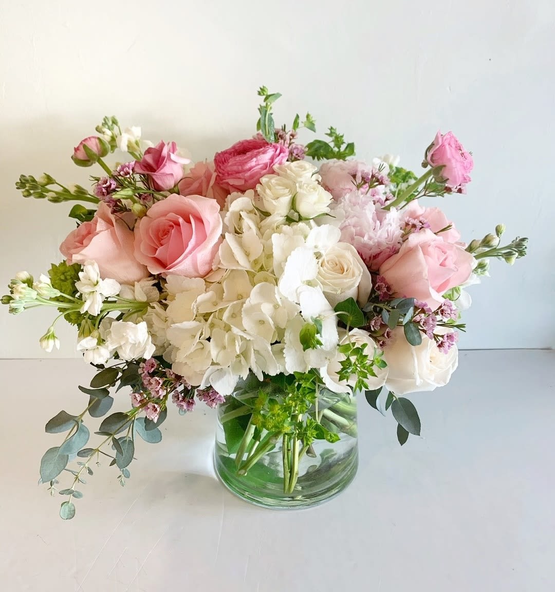 Pink and white rose bouquet in a clear glass vase