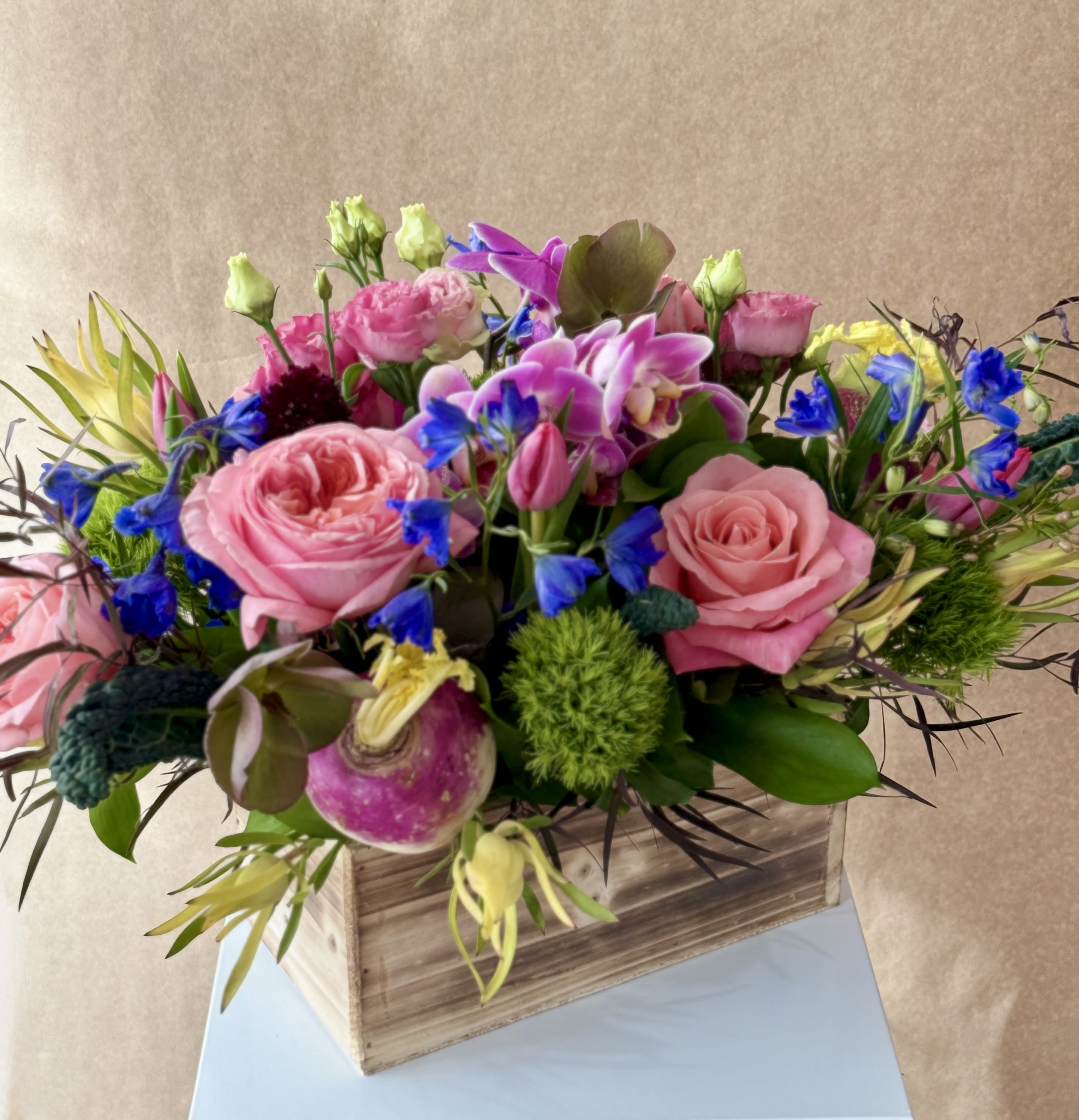 Amber - "Amber is the color of your energy." Orchids, Rutabaga, Kale, Roses, Leucadendron and Thistle with seasonal accents, arranged in a wooden box.