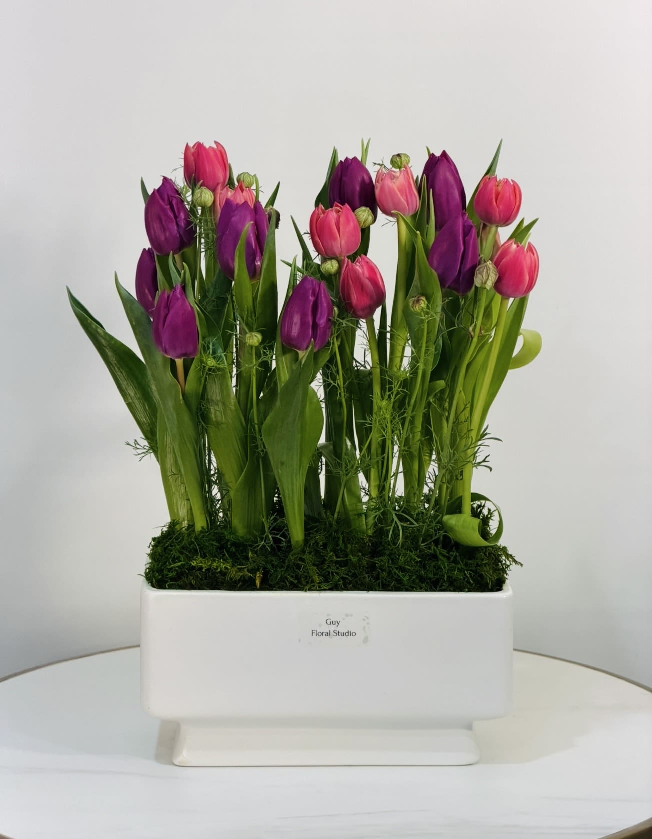 Spring Tulip  - Spring Tulip is a fresh and vibrant floral arrangement featuring premium pink and purple tulips, beautifully designed in a modern white ceramic container with natural moss details. This arrangement captures the beauty of spring with its bright colors, clean structure, and natural elegance. Perfect for birthdays, celebrations, or simply to brighten someone’s day, Spring Tulip is handcrafted by Guy Floral Studio using only fresh, high quality tulips. The combination of bold pink and rich purple tones creates a lively and eye catching design that fits any home or office. We offer same day flower delivery in Beverly Hills, Bel Air, West Hollywood, Beverly Grove, Santa Monica, Culver City, Studio City, Encino, Sherman Oaks, Hollywood Hills, and nearby Los Angeles areas.
